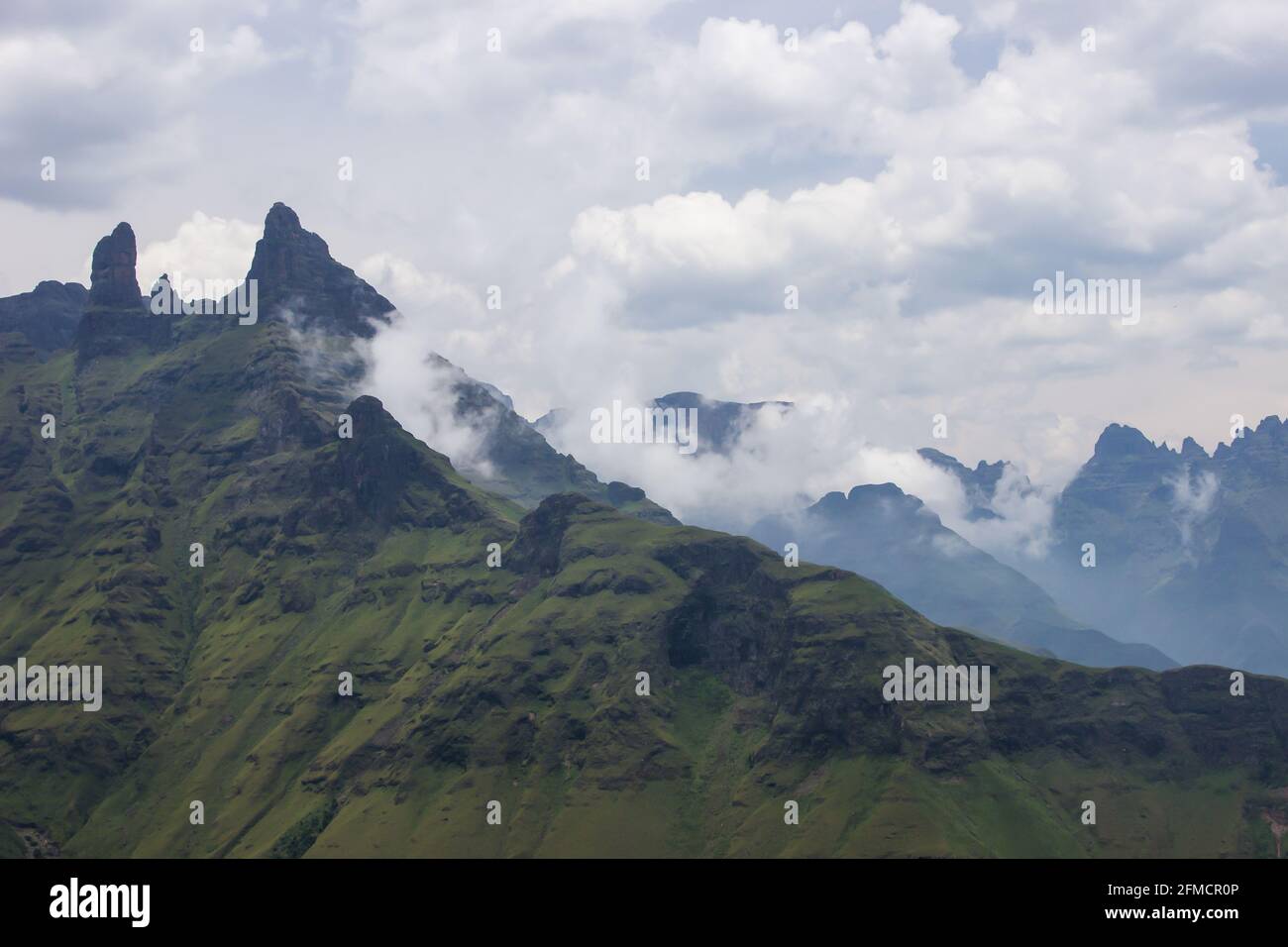 Des nuages commencent à se former entre les hauts pics de basalte déchiquetés des montagnes du Drakensberg, une partie du grand escarpement de l'Afrique du Sud Banque D'Images