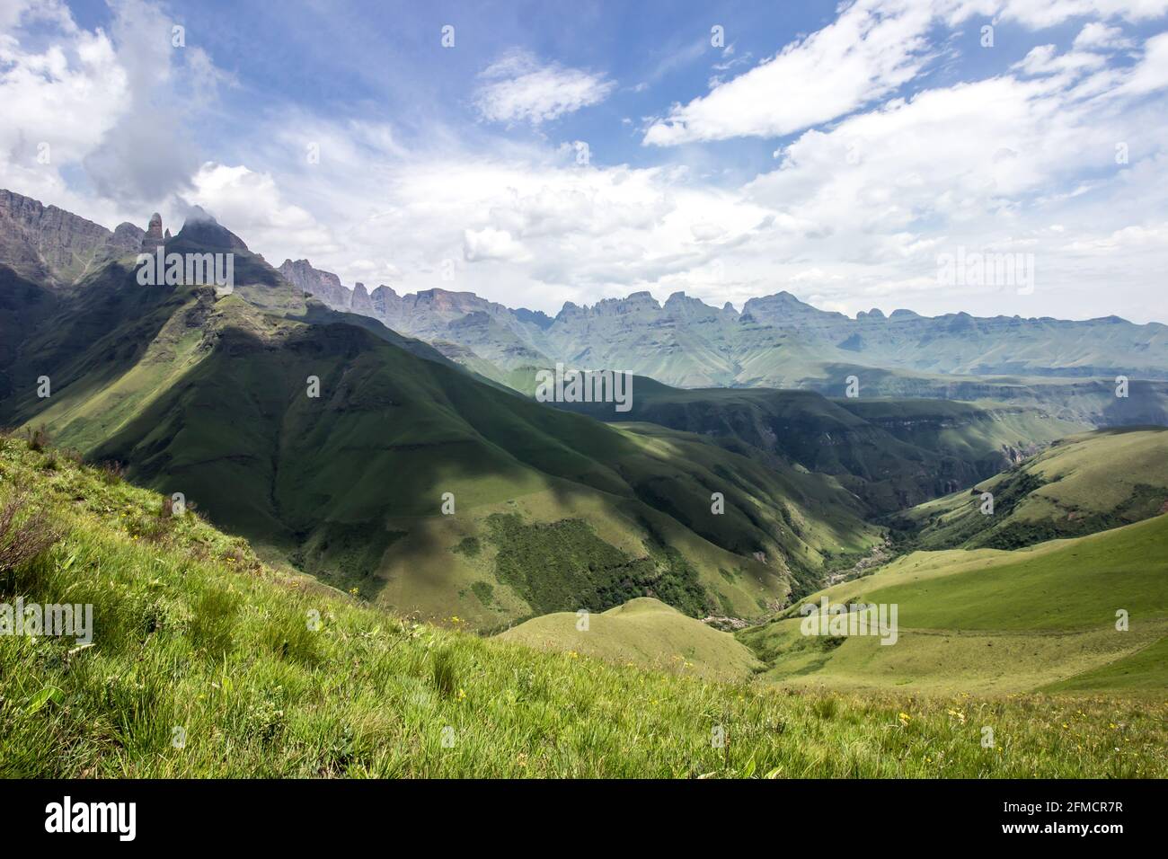 Les nuages qui se rassemblent, jetant des ombres sur une vallée fluviale, entourée par les sommets déchiquetés des montagnes du Drakensberg en Afrique du Sud Banque D'Images