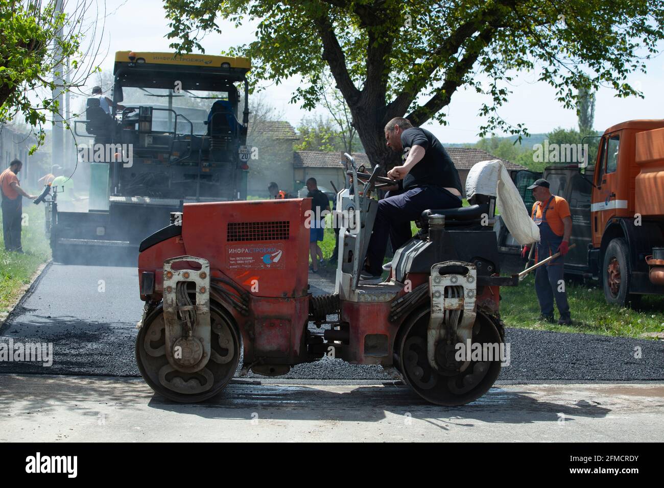 Mihaltsi, Bulgarie - Mai 7 2021: Machines de pavage avec ouvriers pendant l'installation de la couche d'asphalte: Camions, finisseur et rouleaux Banque D'Images