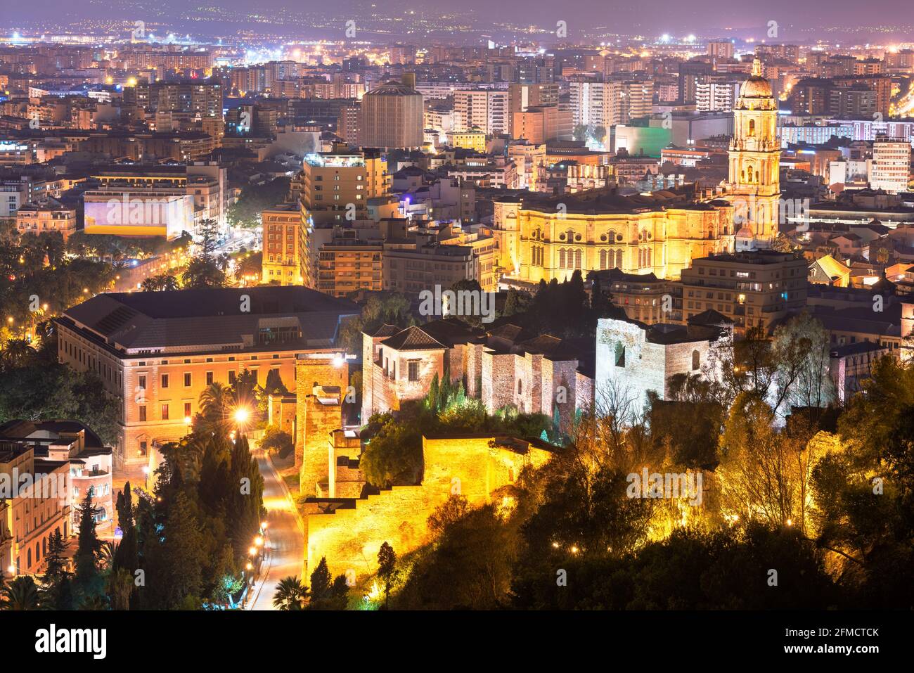 Malaga, Espagne vue sur la Parroquia Santiago Apostol Malaga (église de Santiago Apostol) le long de la ville avec les vieux murs de la citadelle la nuit. Banque D'Images