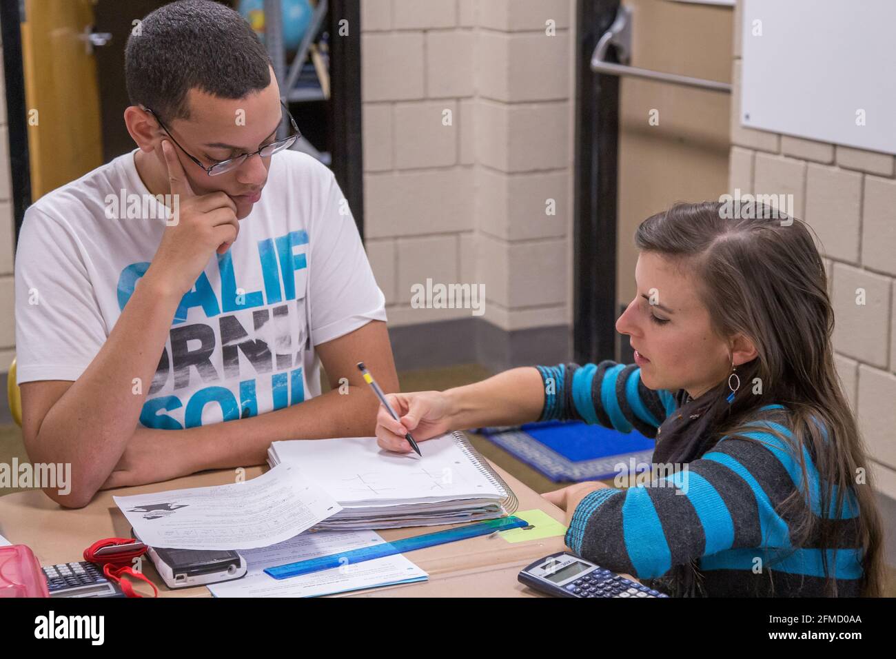 Enseignant aidant les élèves du secondaire dans la salle de classe Banque D'Images