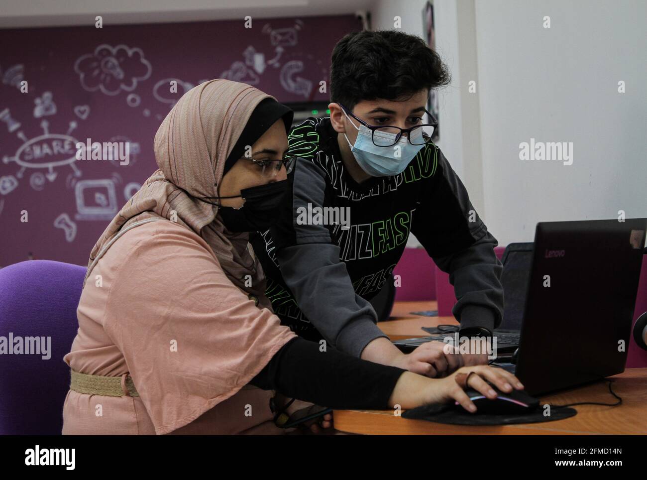 Gaza. 26 avril 2021. Nour al-DIN Fifil (R) travaille sur son ordinateur portable à Gaza, le 26 avril 2021. Nour al-DIN Fifil, un enfant palestinien de la ville de Gaza, est connu pour ses compétences en programmation et en conception de jeux électroniques. POUR ALLER AVEC 'Feature: Gazan enfant excelle dans la programmation, la conception de jeux électroniques' Credit: Rizek Abdeljawad/Xinhua/Alay Live News Banque D'Images
