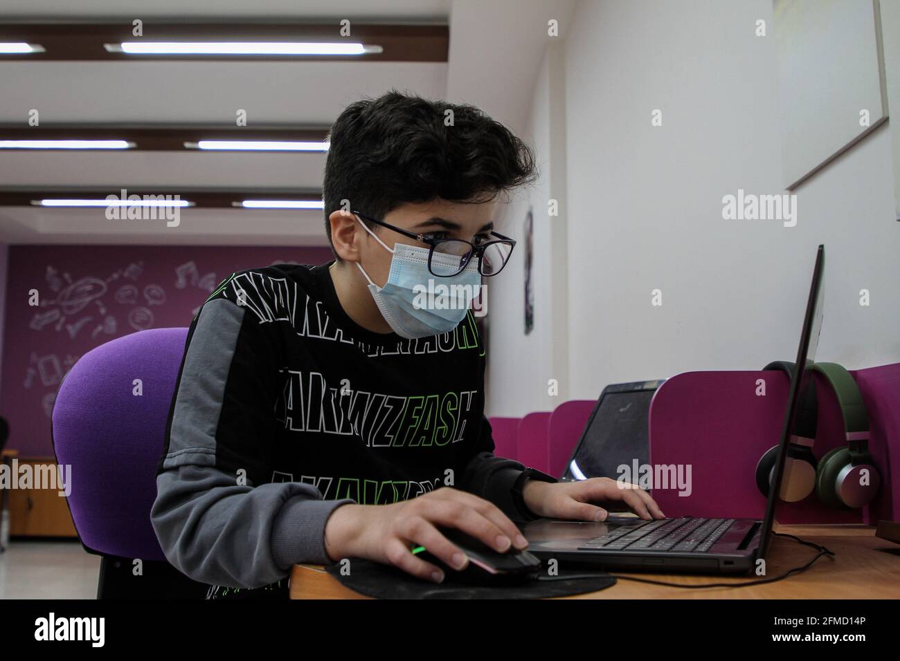 Gaza. 26 avril 2021. Nour al-DIN Fifil travaille sur son ordinateur portable à Gaza, le 26 avril 2021. Nour al-DIN Fifil, un enfant palestinien de la ville de Gaza, est connu pour ses compétences en programmation et en conception de jeux électroniques. POUR ALLER AVEC 'Feature: Gazan enfant excelle dans la programmation, la conception de jeux électroniques' Credit: Rizek Abdeljawad/Xinhua/Alay Live News Banque D'Images