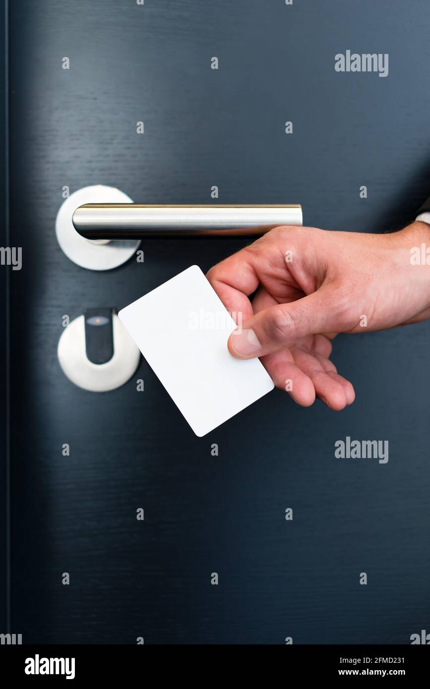 Porte de l'hôtel - Jeune homme tenant une keycard en face de la sonde électronique d'une porte de la chambre Banque D'Images