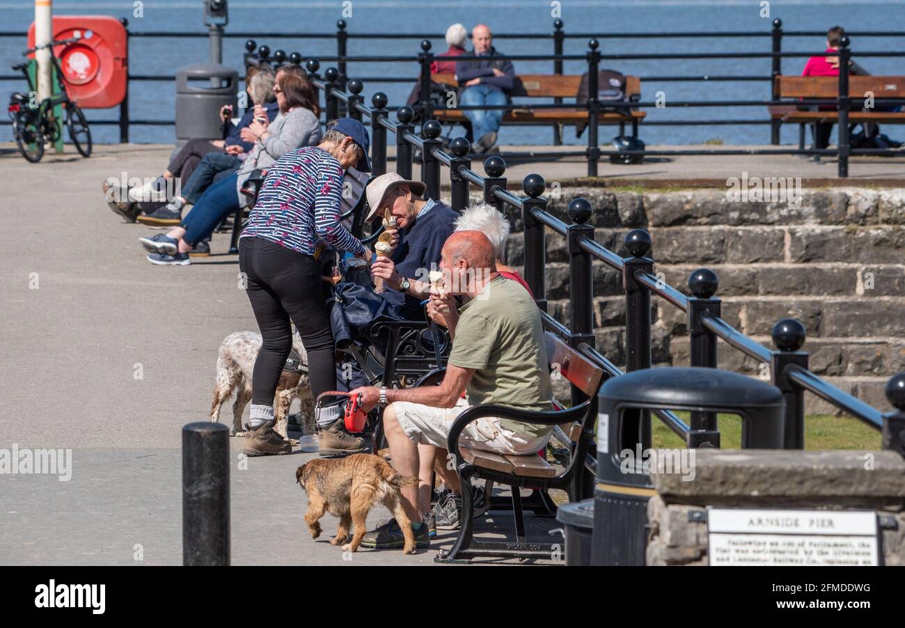 Les visiteurs qui mangent de la glace sur la jetée d'Arnside, Arnside, Cumbria, Royaume-Uni Banque D'Images