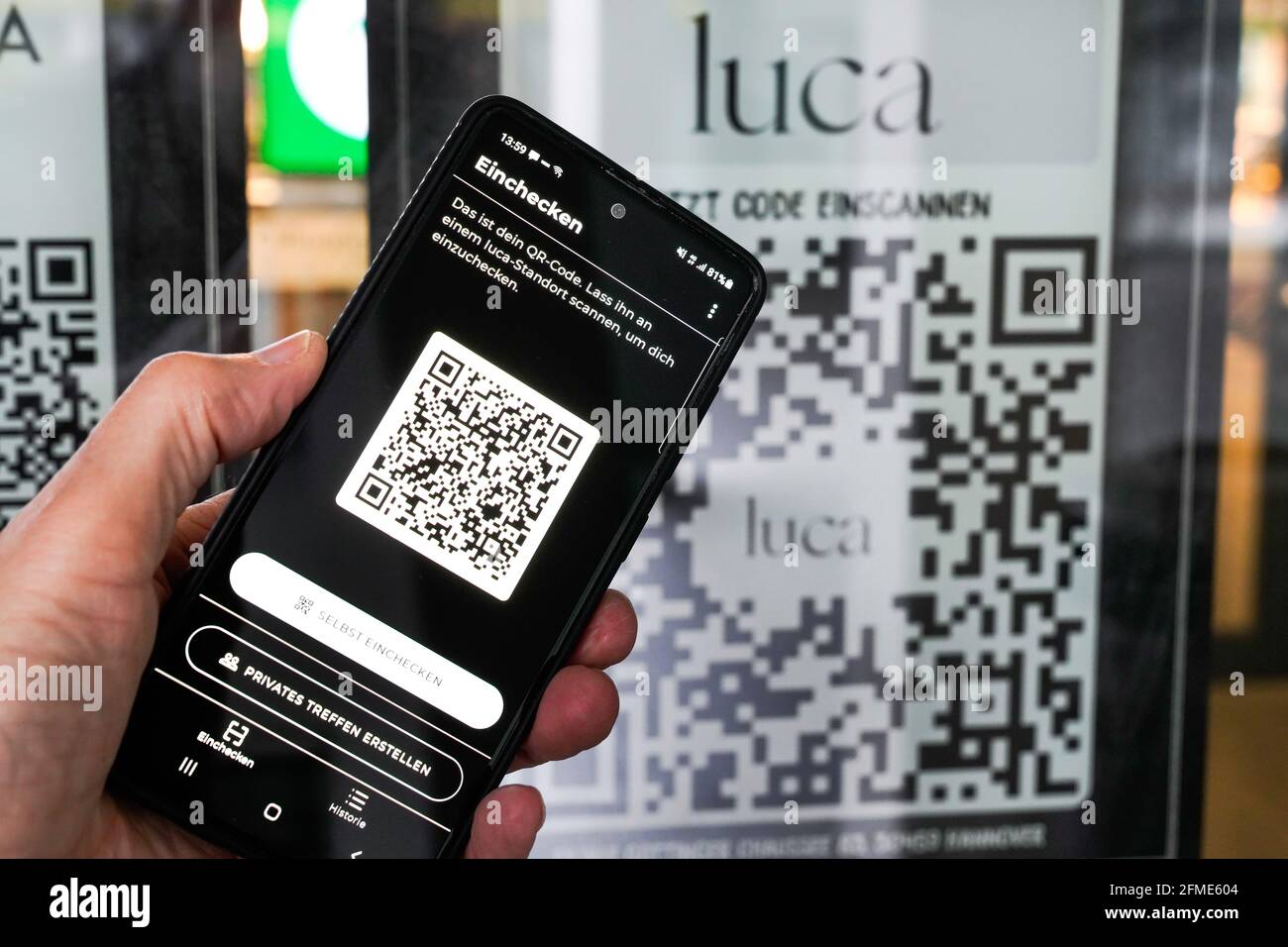 L'application Luca sur un smartphone scanne un code QR Luca à l'entrée d'un marché alimentaire à Hanovre. Vous pouvez enregistrer et sortir avec votre téléphone mobile et cela permet de tracer les chaînes d'infection de corona. Hanovre, Allemagne, le 8 mai 2021 --- Luca-App auf einem smartphone scannt einen Luca QR-Code Am Eingang eines Lebensmittelmarktes à Hanovre. Betrieb einer Bürgen und Verkauf von Dienstleistungen. Hanovre, 8.5.2021 Banque D'Images