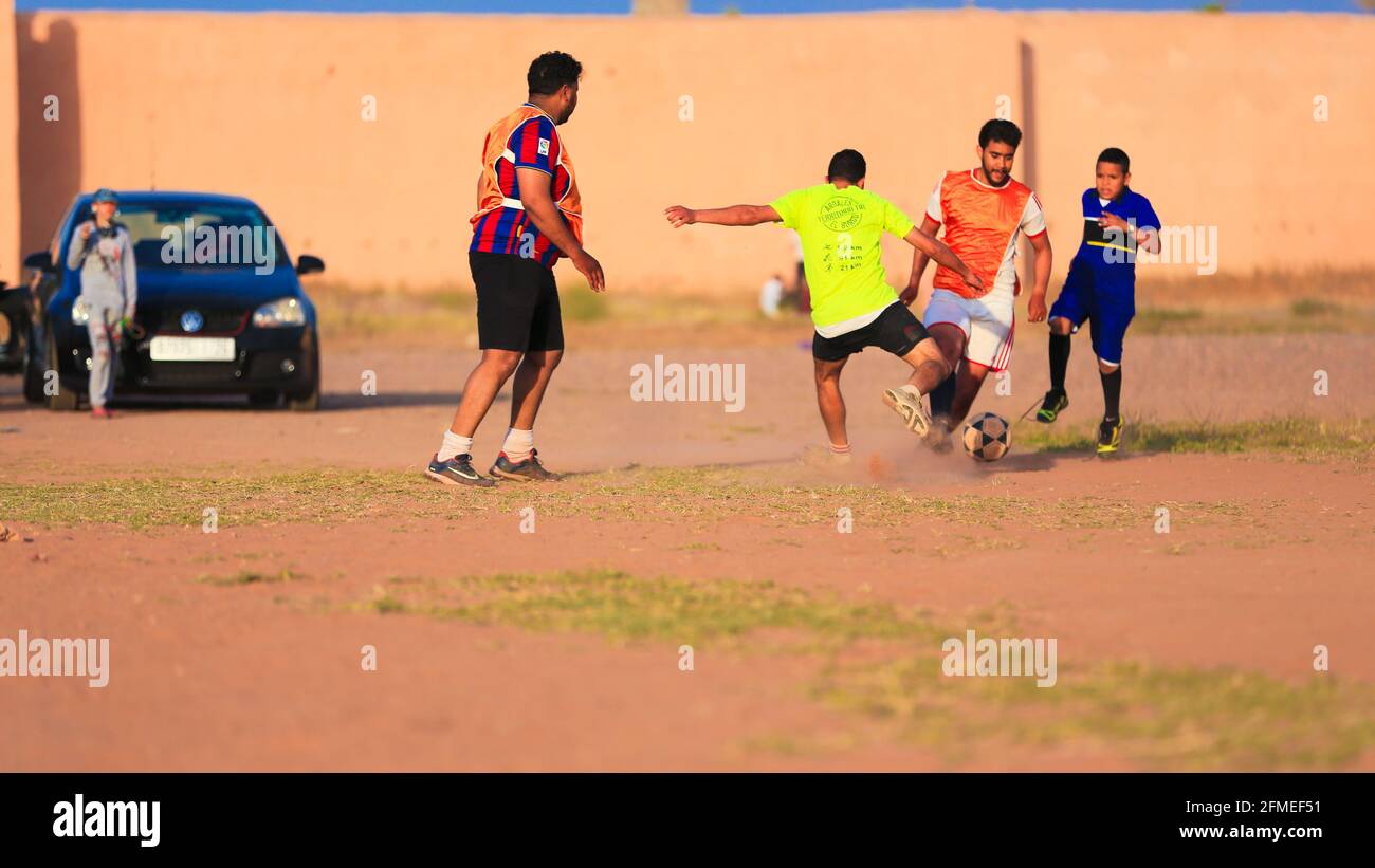 Marrakech, Maroc - 25 AVRIL 2021 : hommes jouant au football sur un terrain poussiéreux Marrakech au Maroc Banque D'Images Marrakech, Maroc - 25 AVRIL 2021 : hommes jouant au football sur un terrain poussiéreux Marrakech au Maroc Banque D'Images