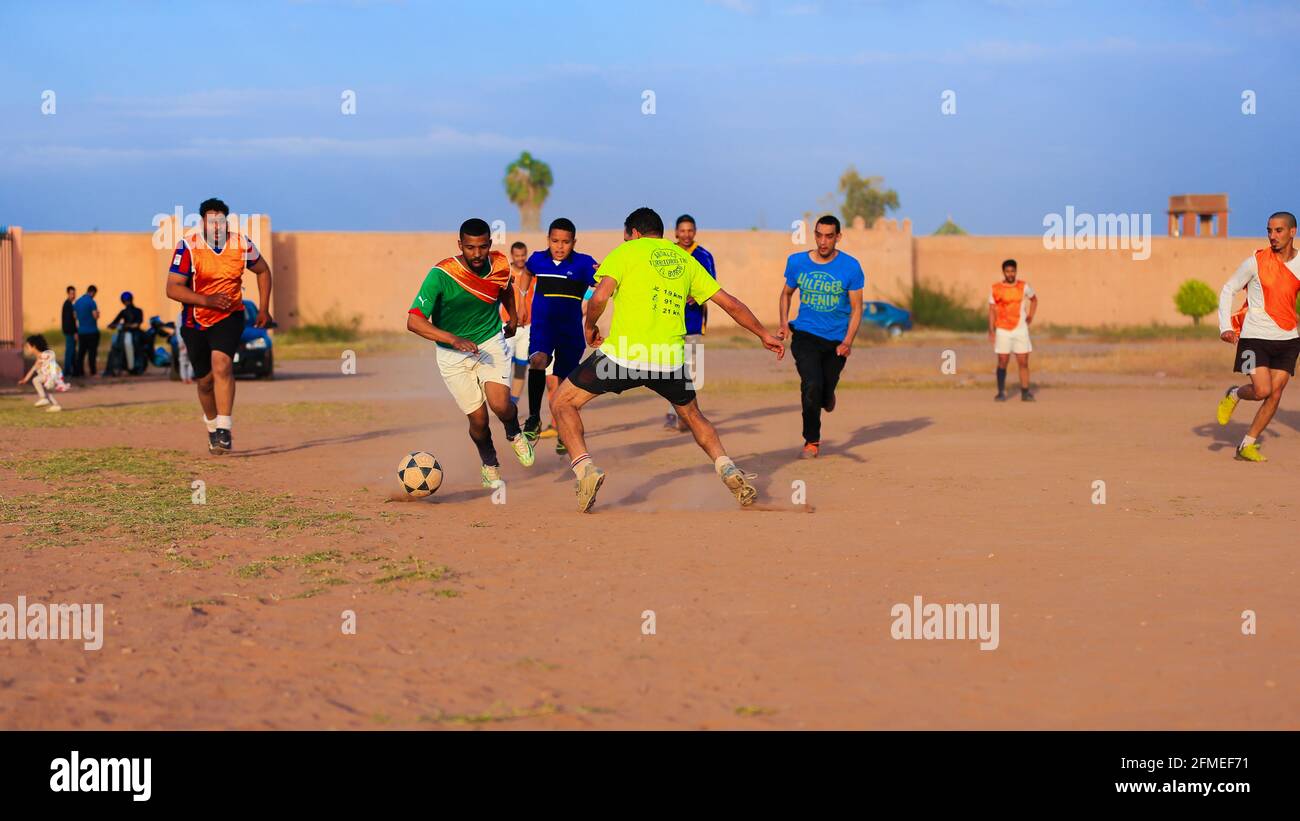 Marrakech, Maroc - 25 AVRIL 2021 : hommes jouant au football sur un terrain poussiéreux Marrakech au Maroc Banque D'Images