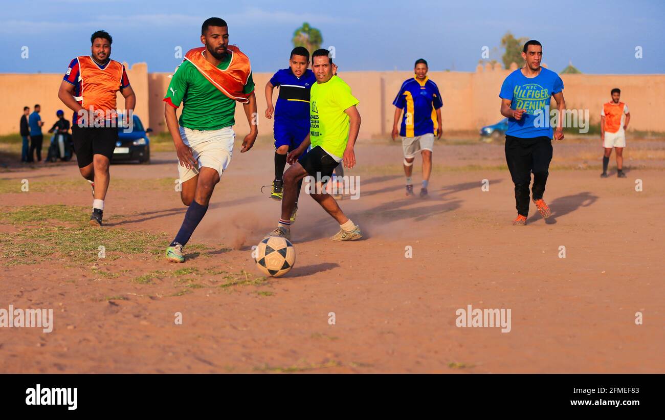 Marrakech, Maroc - 25 AVRIL 2021 : hommes jouant au football sur un terrain poussiéreux Marrakech au Maroc Banque D'Images