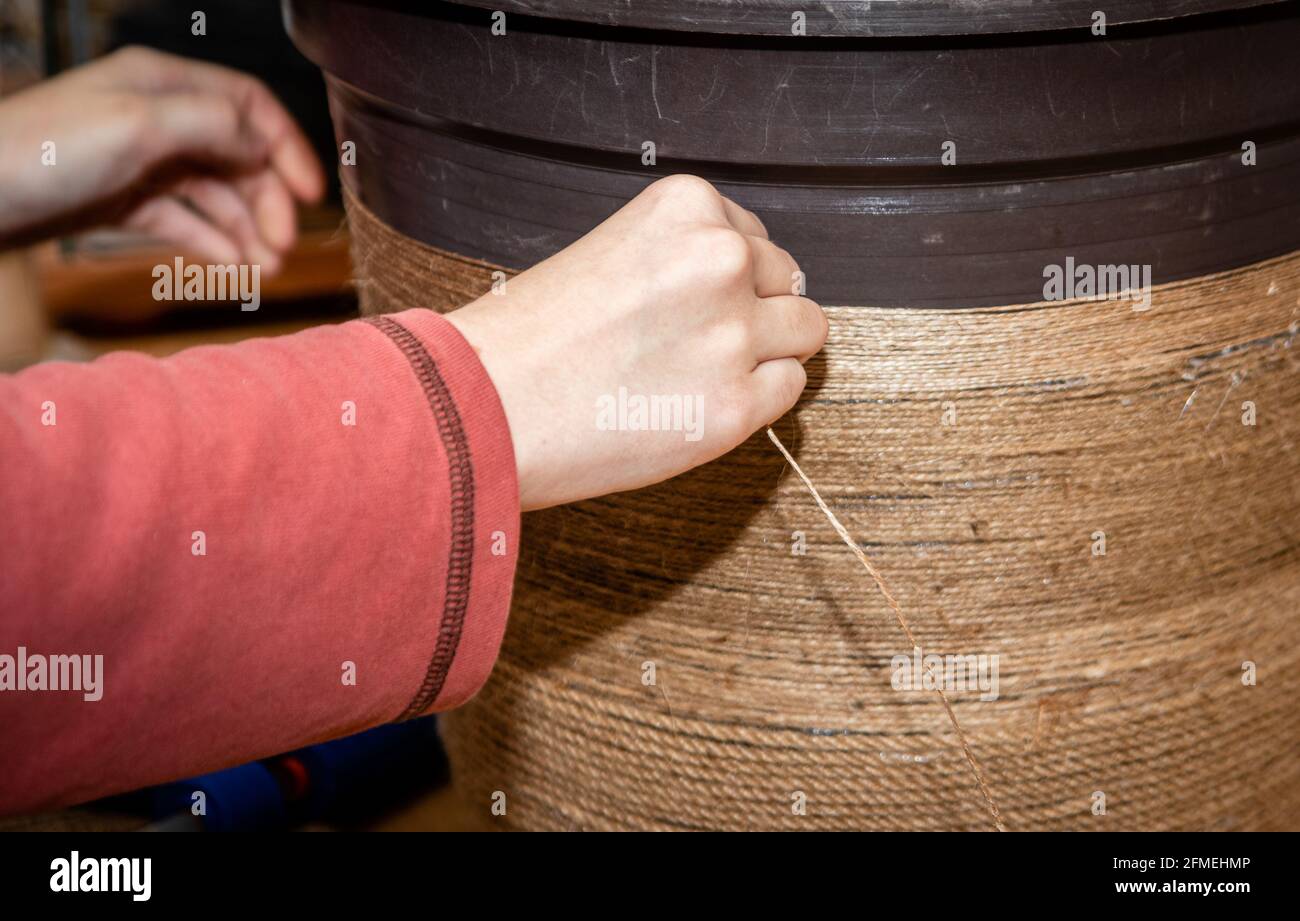 Artisan, artiste fixe la décoration de corde sur le grand pot de fleur en plastique. Banque D'Images