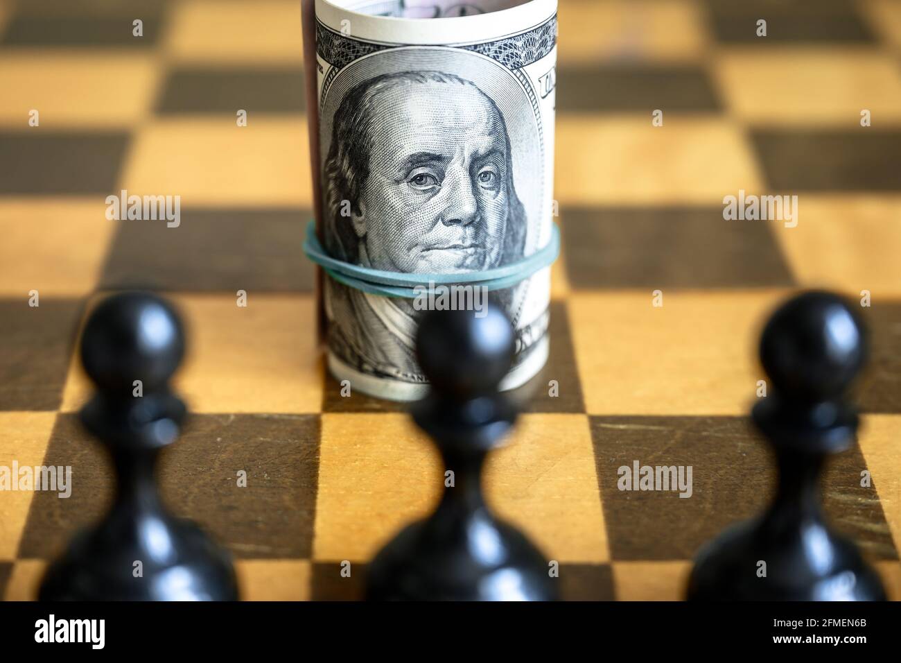 Dollar avec Franklin contre les chiffres des échecs, argent américain sur chessboard en bois. Symbole de la finance et jeu d'échecs. Concept de la stratégie monétaire, investissement, u Banque D'Images