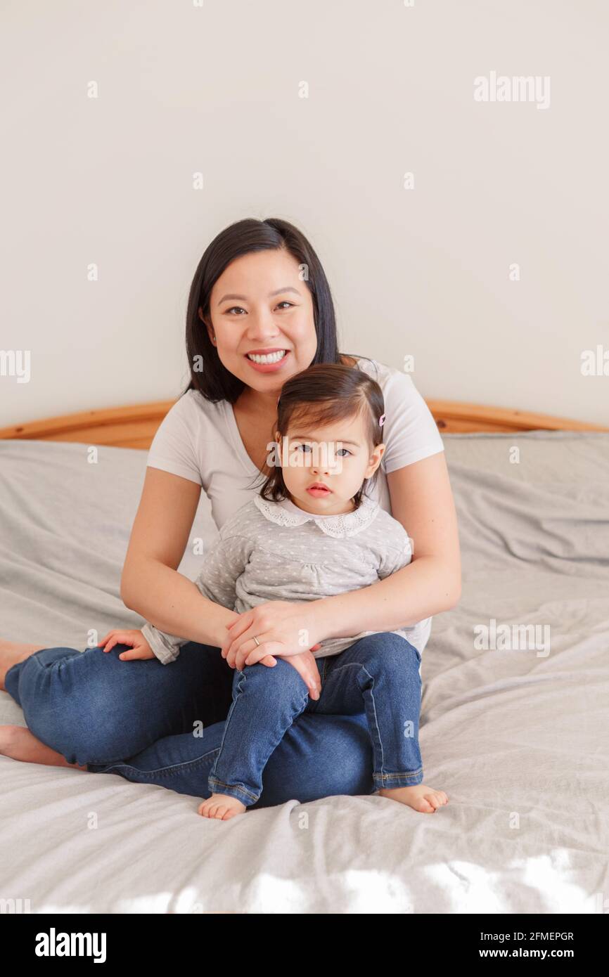 Femme asiatique chinoise qui s'embrasse au lit avec une petite fille à la  maison. Fille fille enfant avec maman ensemble. Une mère qui s'embrasse avec  une petite fille. ETH Photo Stock -