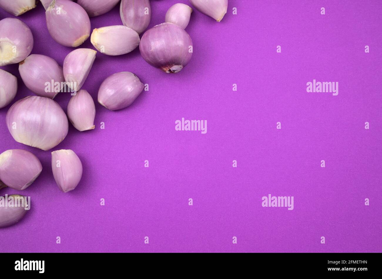 Épluchez les oignons frais à plat, posez-les sur fond violet. Espace de copie pour le texte ou la conception, la vue de dessus, le style d'image horizontal. Banque D'Images