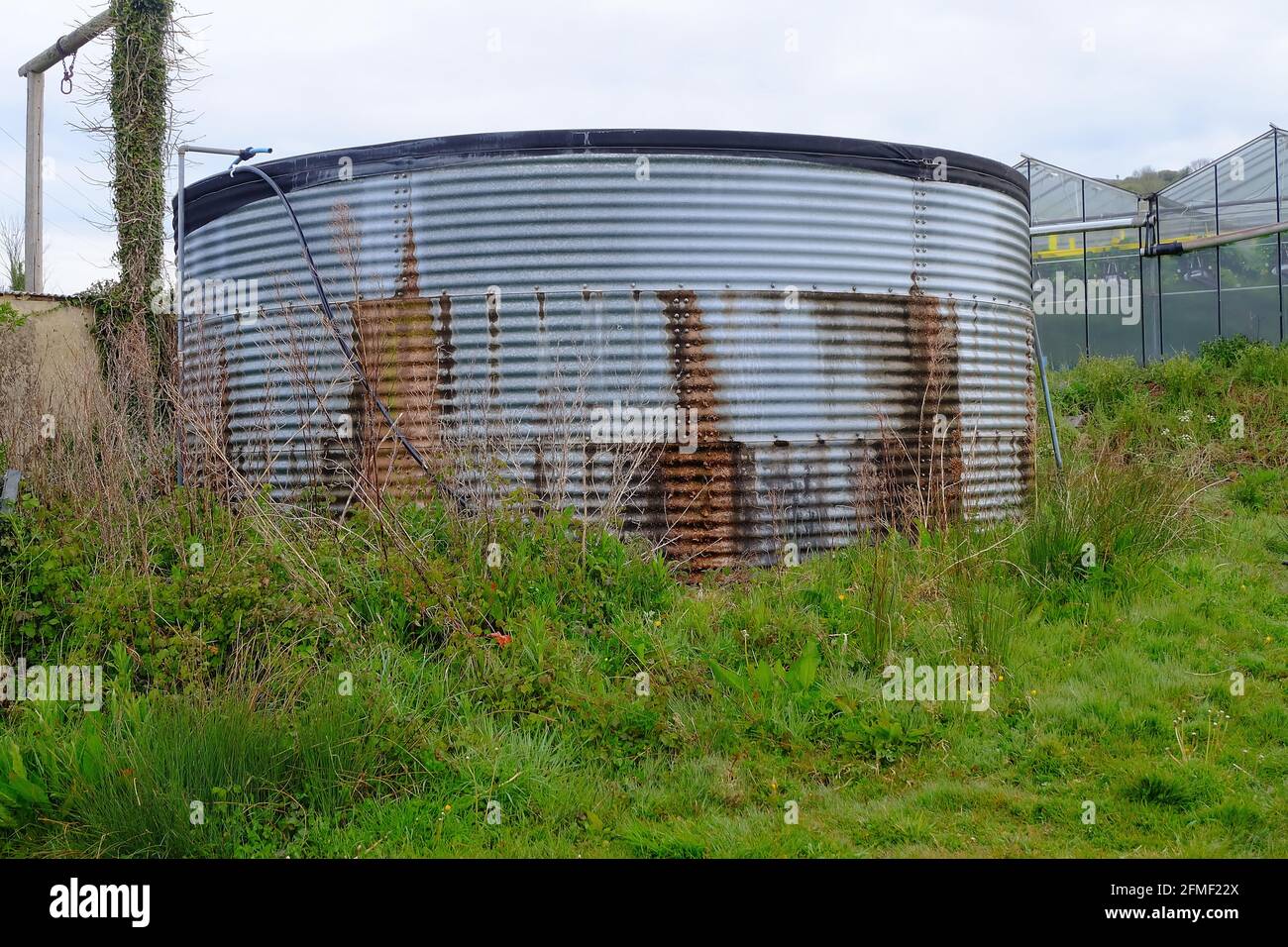 2021 mai - ancien réservoir de stockage d'eau en acier utilisé à une ferme fruitière Banque D'Images