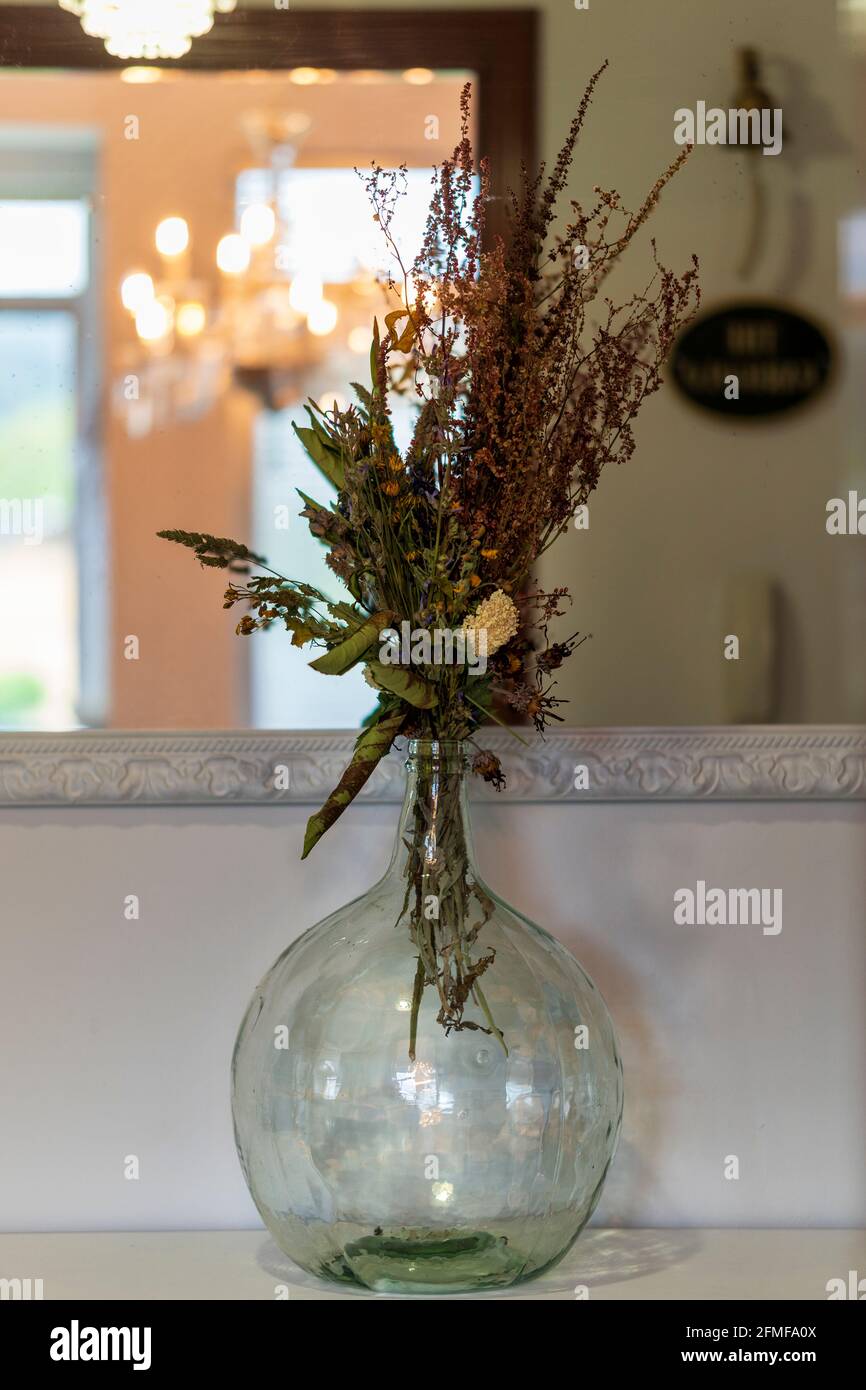 Demijohn avec fleurs séchées et chandelier miroir Banque D'Images