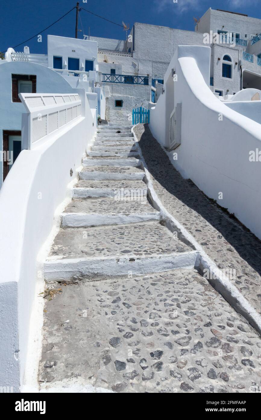 Passerelle traditionnelle grecque pavée avec murs blanchis à la chaux menant à un groupe de maisons sur l'île de Santorini Grèce. Banque D'Images