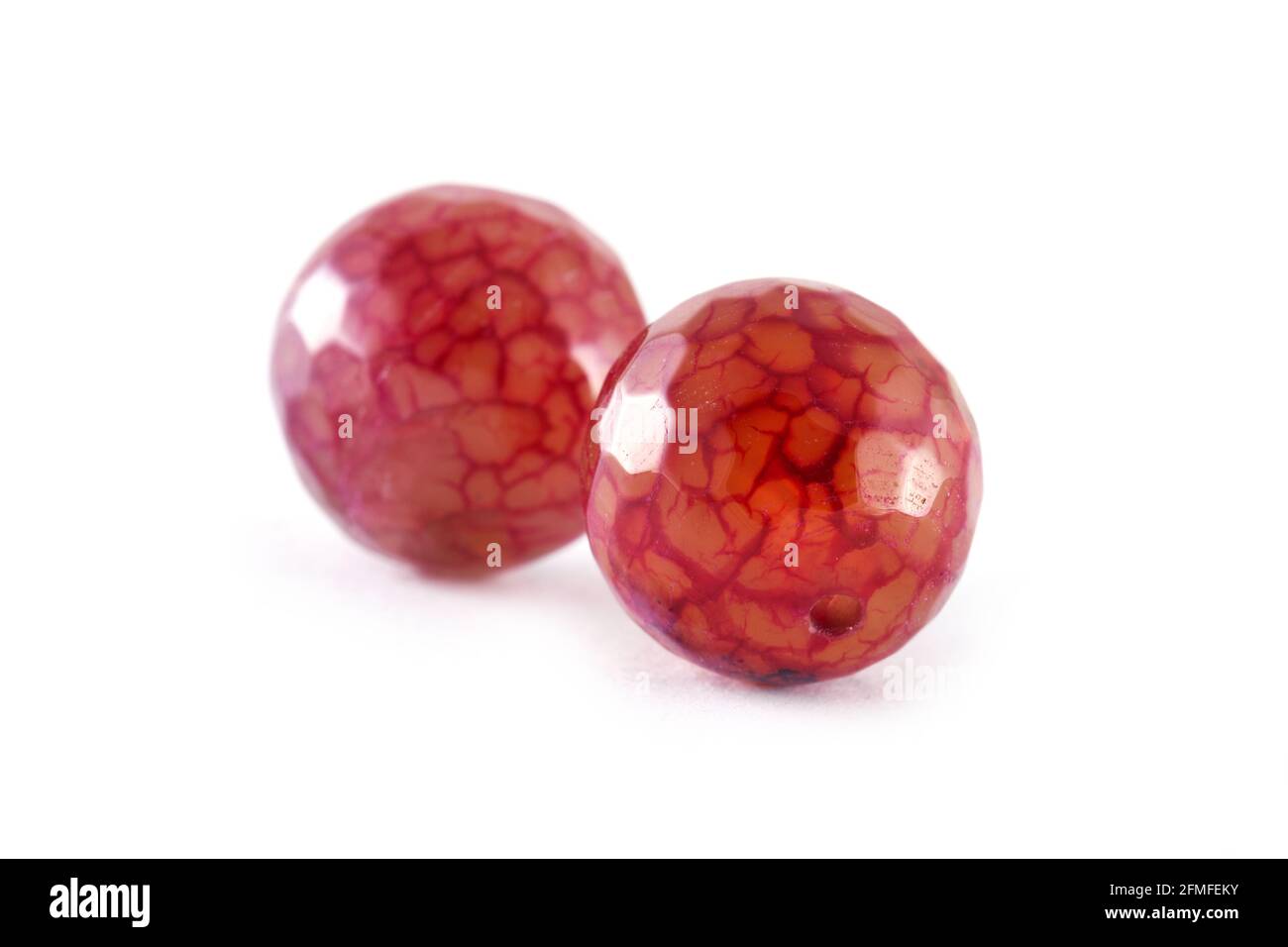 Perles d'agate rouge cramoisi à motifs isolées sur des perles d'agate rondes blanches, pierres semi-précieuses. Perles minérales naturelles. Perles en pierres naturelles à cre Banque D'Images