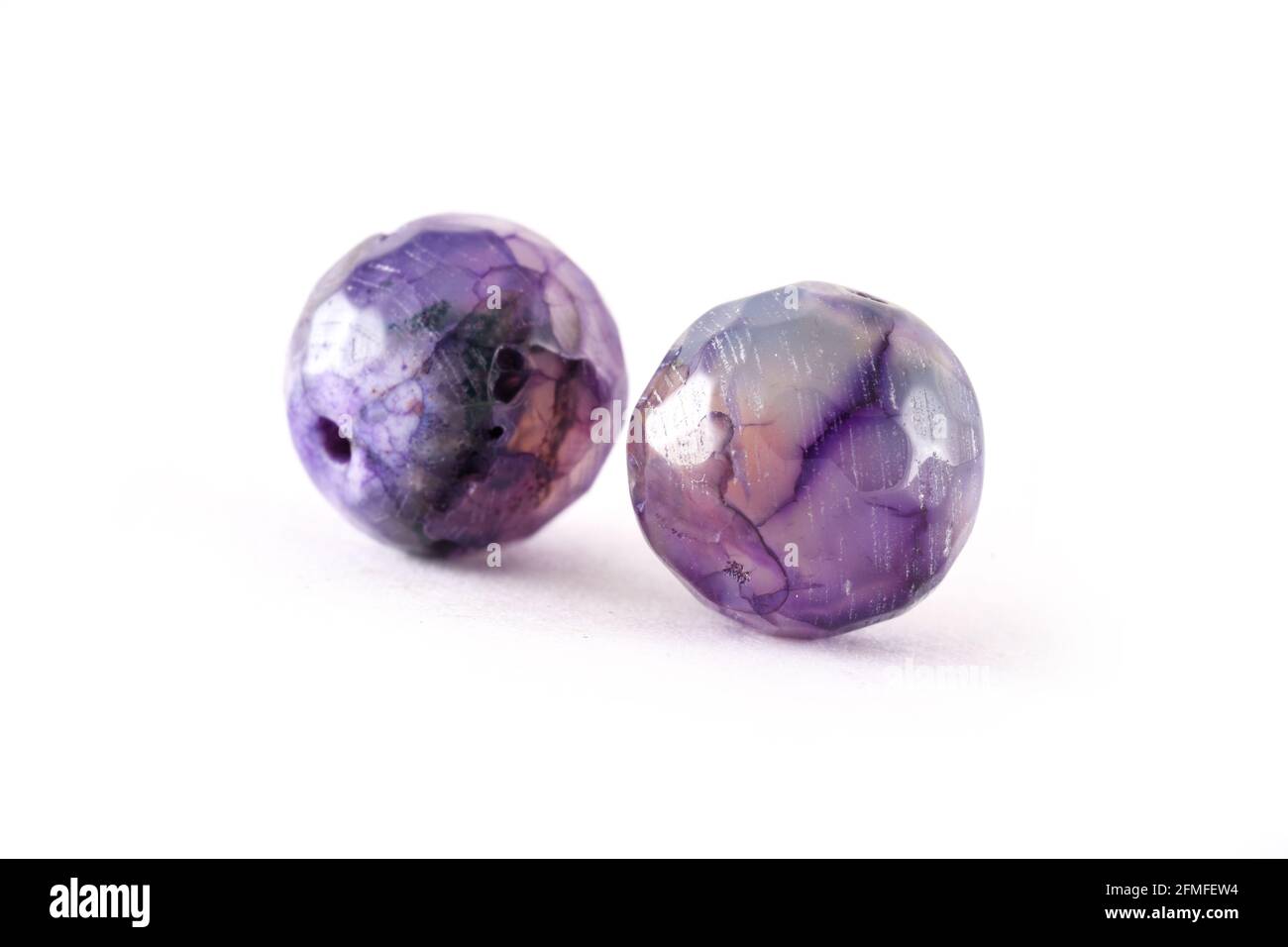 Perles d'agate violet à motifs isolées sur des perles d'agate rondes blanches, pierres semi précieuses. Perles minérales naturelles. Perles en pierres naturelles pour créer j Banque D'Images