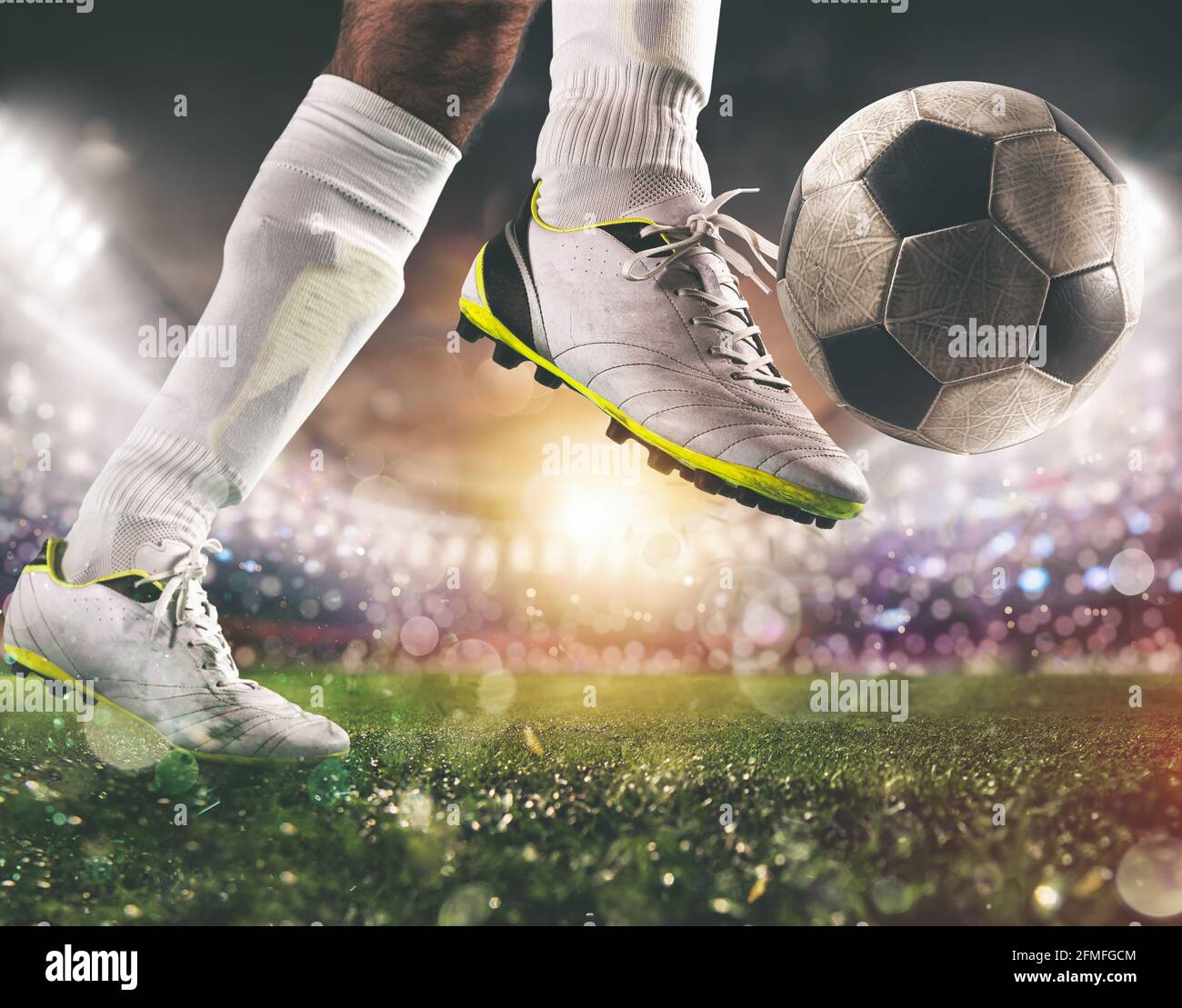 Gros plan d'une scène de football avec un joueur dans un uniforme blanc qui frappe le ballon avec puissance Banque D'Images