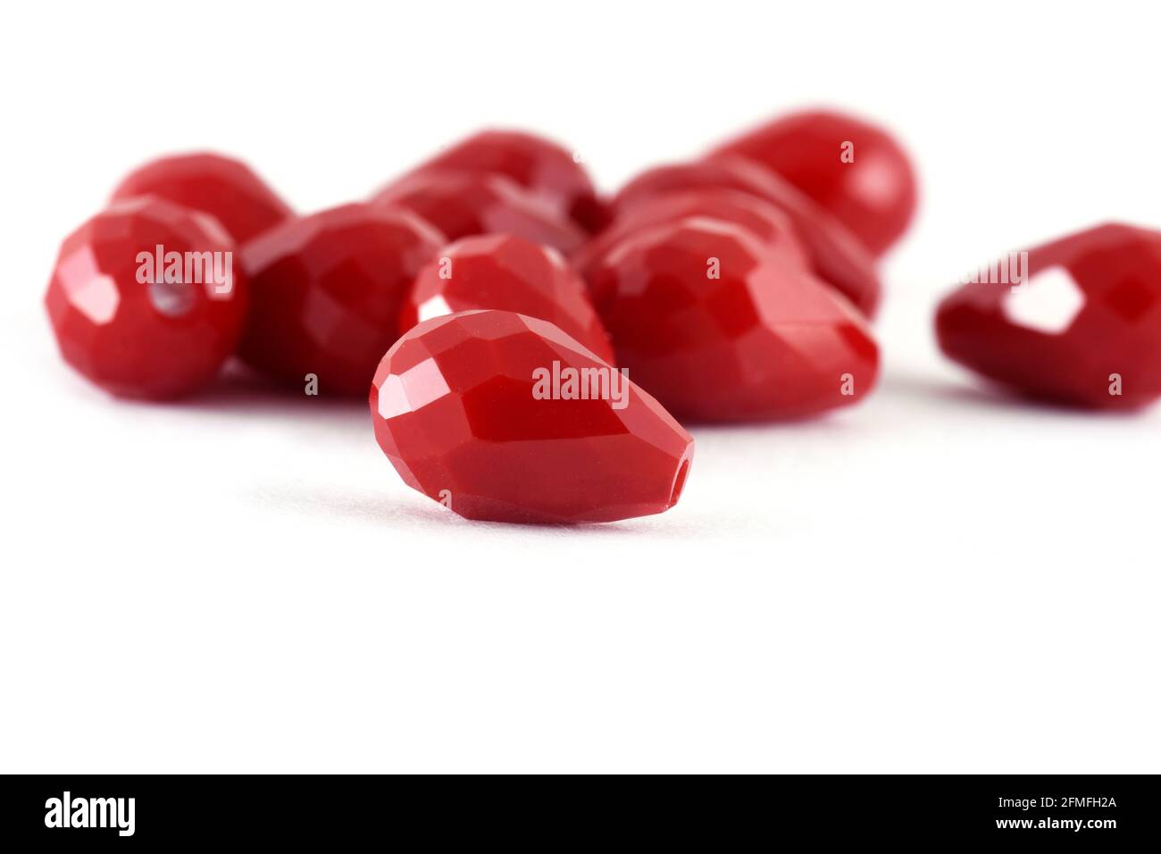 Forme goutte les perles rouges s'étendent sur fond blanc. Arrière-plan ou texture de perles.gros plan, utilisé dans la finition des vêtements de mode. Faire collier de perles ou stri Banque D'Images