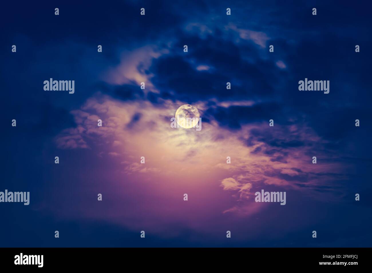 Belle photo d'un ciel nocturne avec ciel nuageux sombre et pleine lune lumineuse. Pleine lune derrière les nuages la nuit. Ton vintage. La lune n'était PAS du fu Banque D'Images