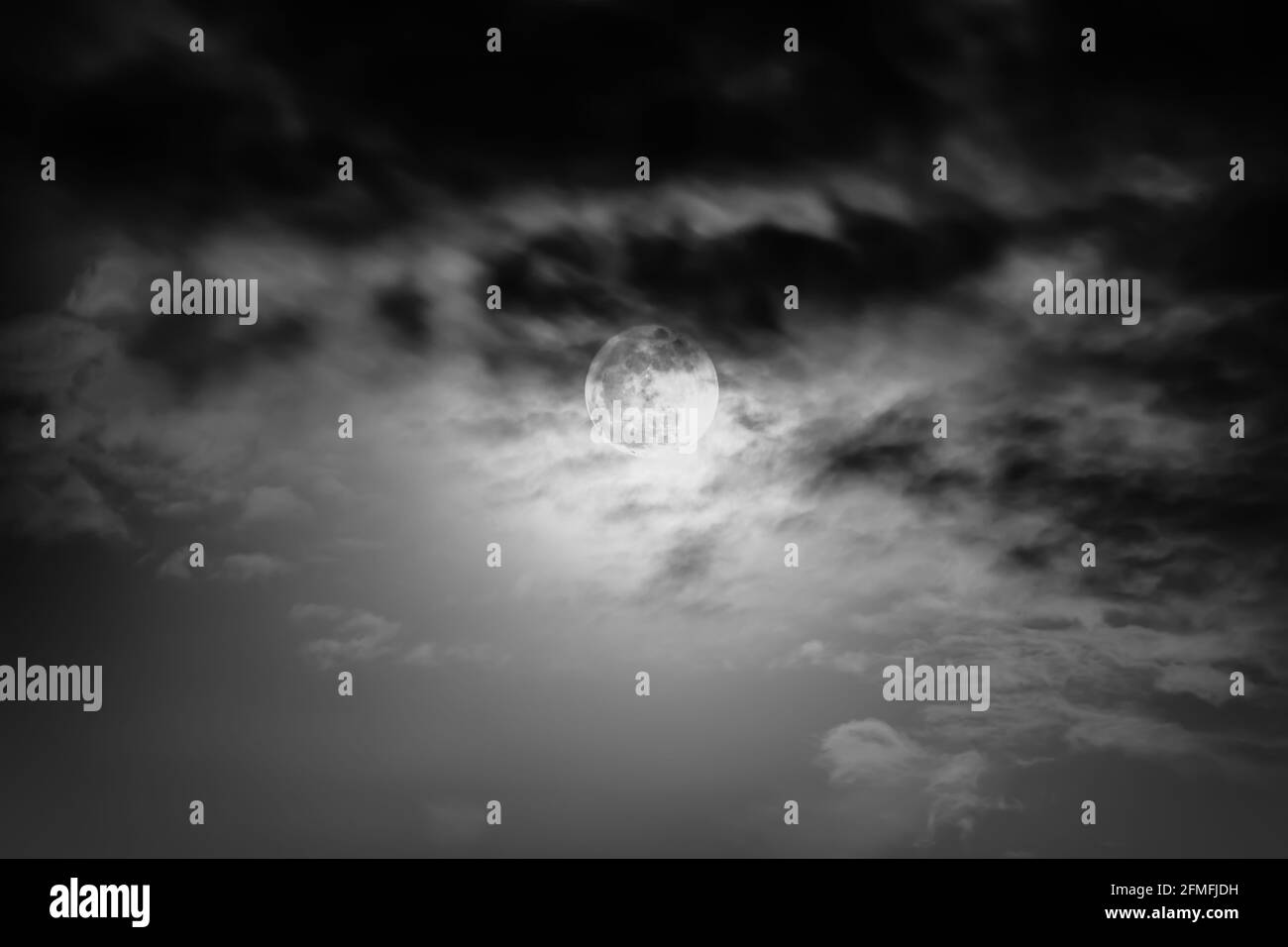 Arrière-plan du ciel nocturne avec nuage et pleine lune avec brillant. Beauté naturelle la nuit avec la lune derrière le nuage dans le style noir et blanc. Effigie vintage Banque D'Images