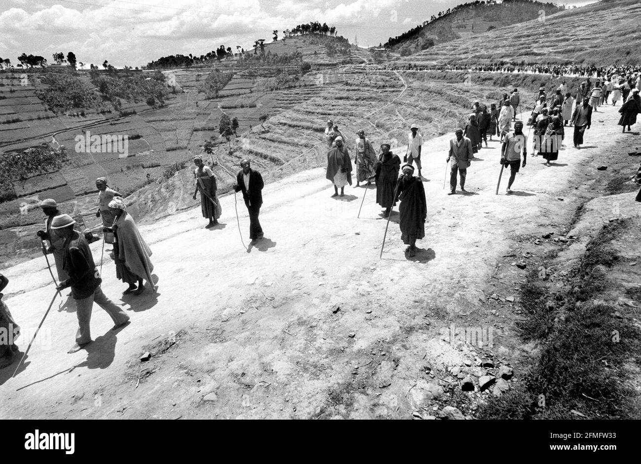 Les gens qui ont été installés de force le 1999 février dans le cadre du programme de villageois « controversé », faisant la queue pour des couvertures de savon et des jerricans au camp de Mucaca après avoir marché depuis leurs villages périphériques. Le camp était un camp de personnes déplacées et abritait jusqu'à récemment 45,000 personnes. Il est maintenant utilisé comme centre de distribution pour l'aide. Il se trouve dans la commune de Cyeru, province de Ruhengeri, Nord-Ouest du Rwanda.14.2.1999 Photo : JOHN VOOS Banque D'Images