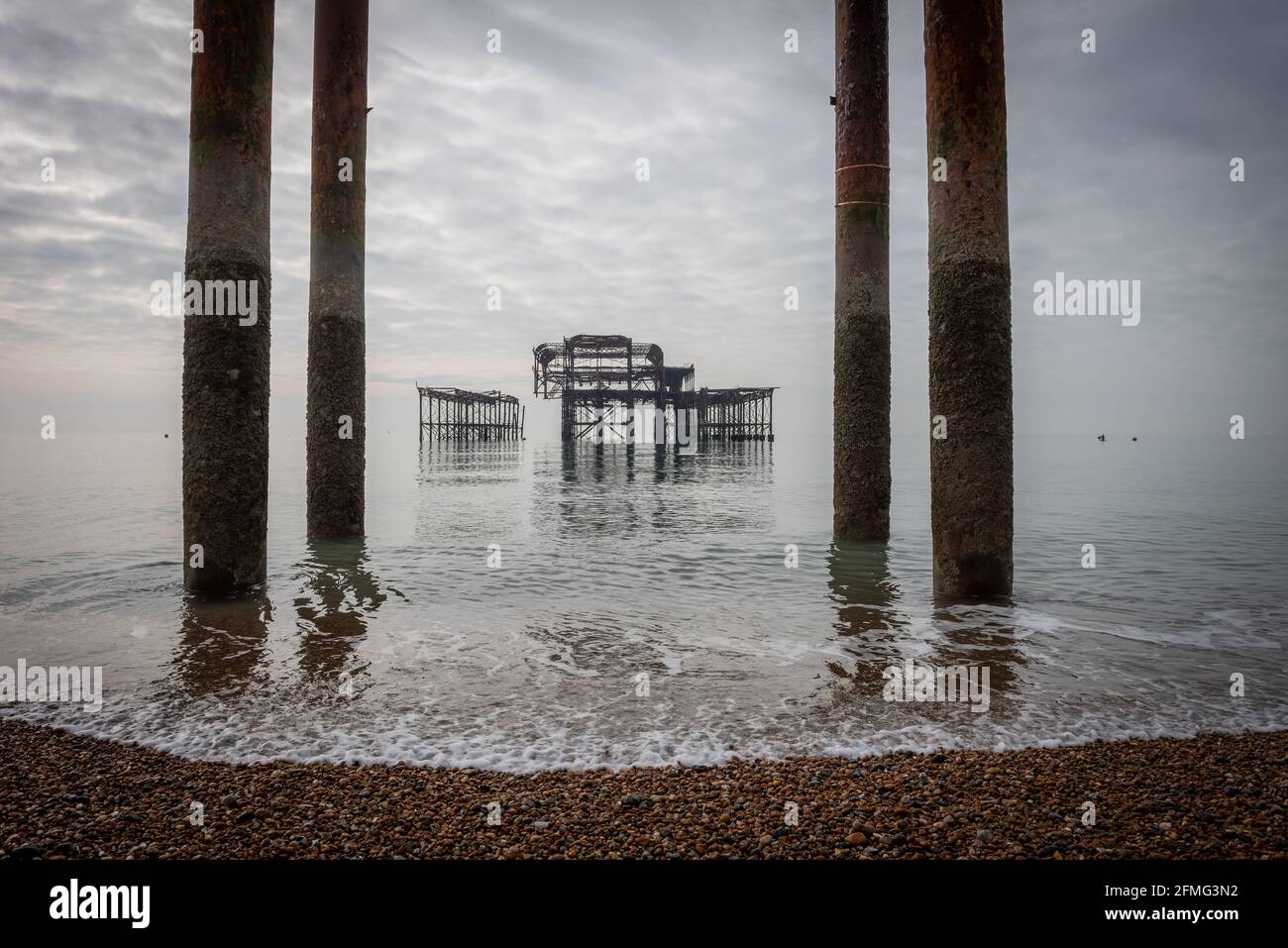 Les ruines tristes de la jetée ouest de Brighton sur une inhabituellement mer calme Banque D'Images