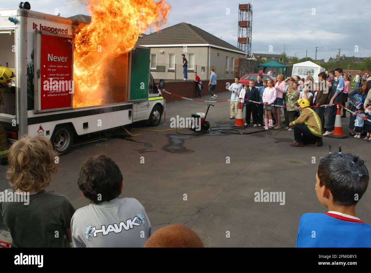 Troon Primary School, Ayrshire, Écosse, Royaume-Uni. Démonstration de la manière dont un foyer à copeaux peut s'enflammer. Lorsque l'huile ou la graisse dans la casserole devient trop chaude et prend feu. Dans la démo, une petite tasse d'eau est versée sur le feu avec l'éruption qui en résulte. Banque D'Images