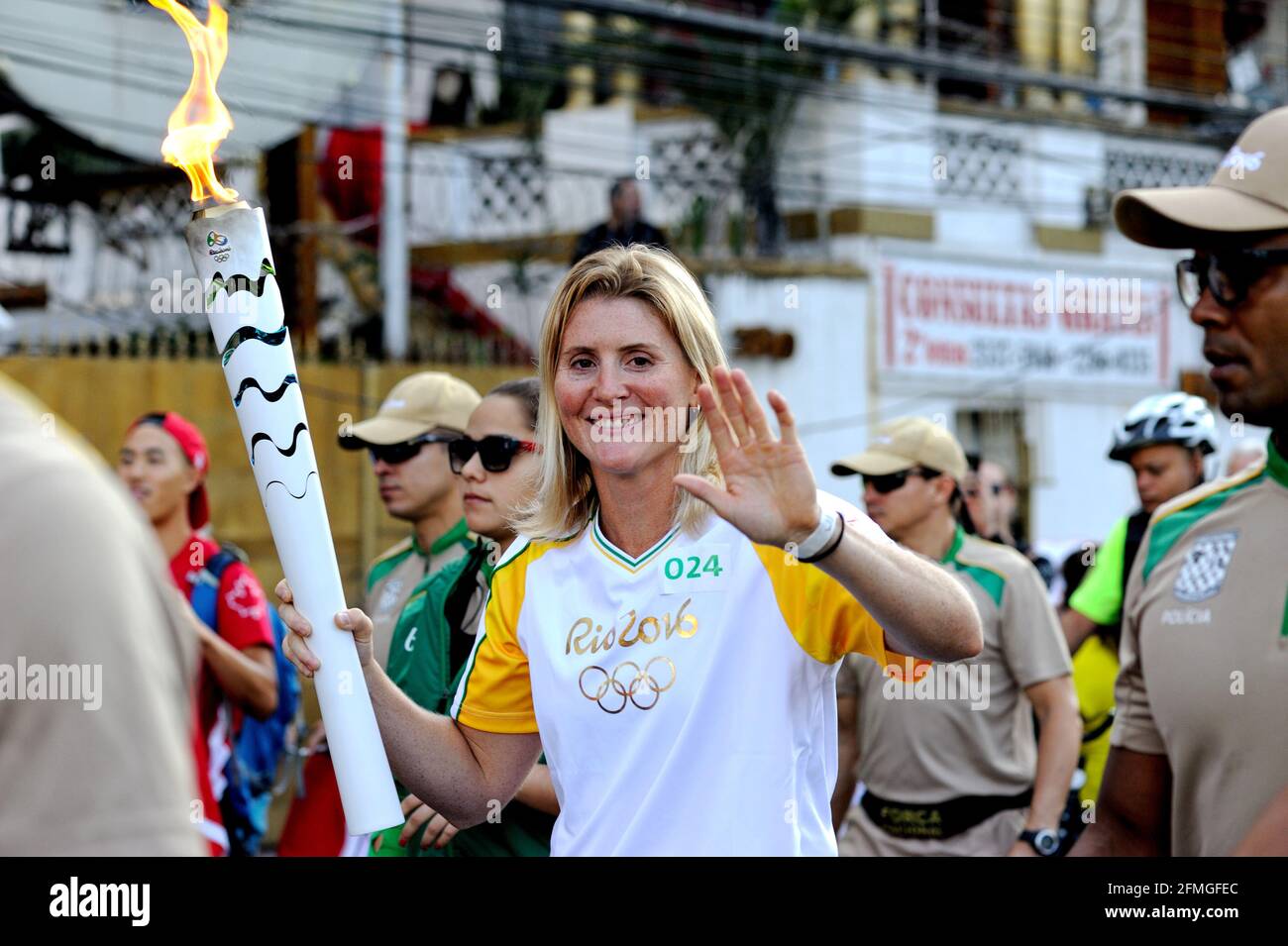 Brésil – le 5 août 2016 : un porteur de flambeaux sourit et fait des vagues pour la caméra pendant les dernières heures du Relais de la flamme olympique 2016 qui s'est tenu à Rio de Janeiro. Banque D'Images