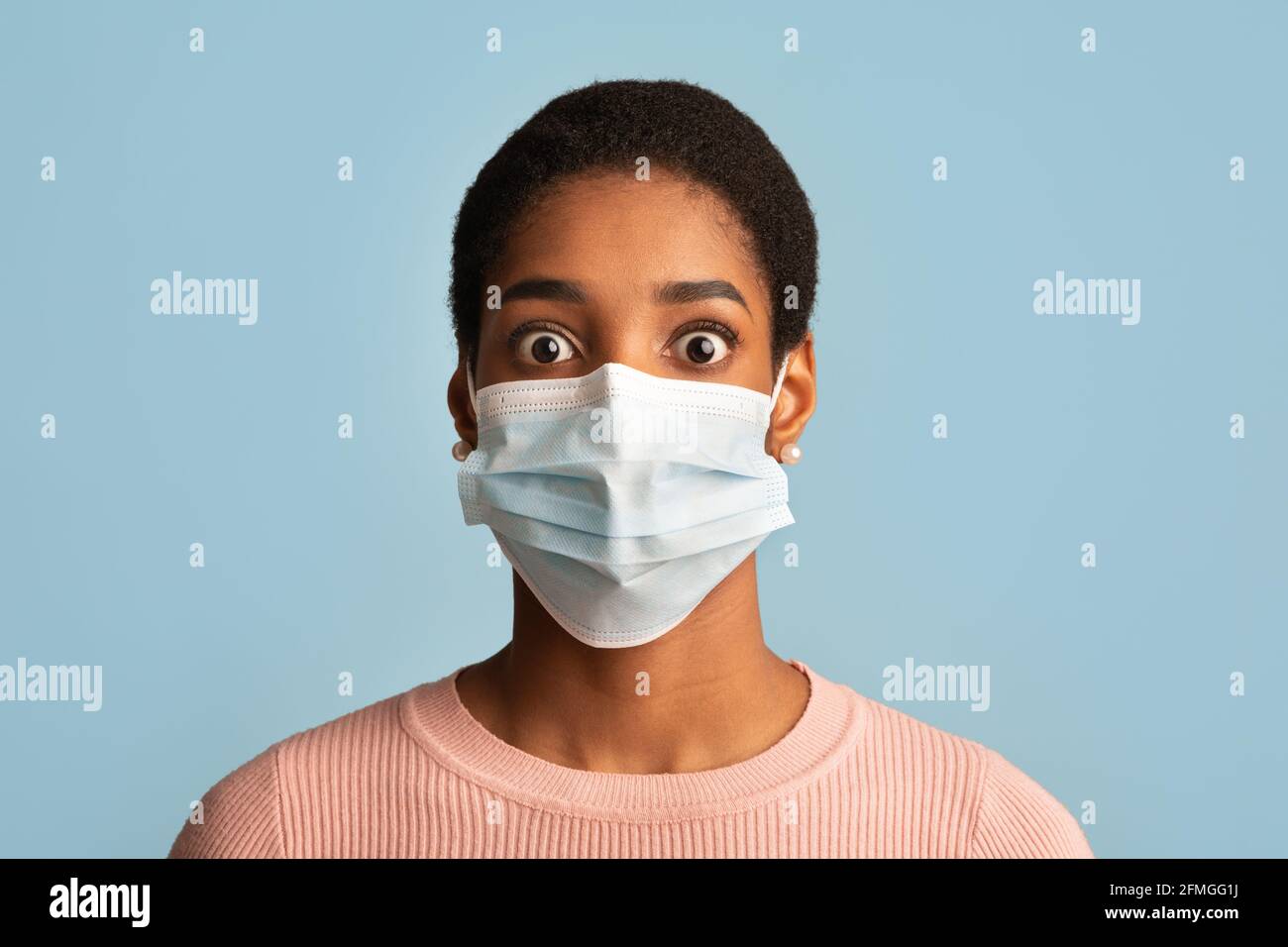 Concept de panique du coronavirus. Portrait d'une femme africaine terrifiée dans un masque médical de protection Banque D'Images