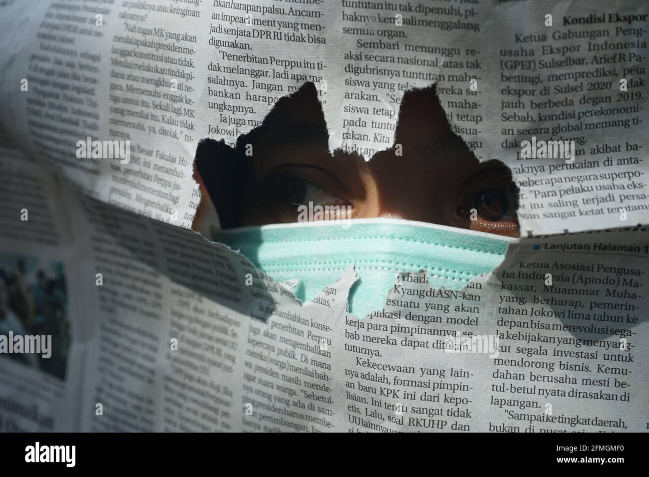Une femme portant un masque avec un journal déchiré dedans avant Banque D'Images