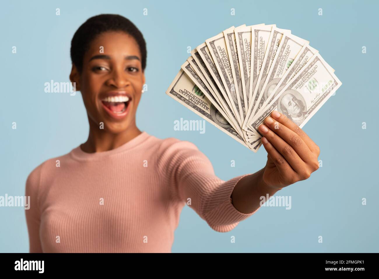 Grand prix. Bonne jeune femme africaine qui fait la démonstration de Dollar Cash Fan à Camera Banque D'Images