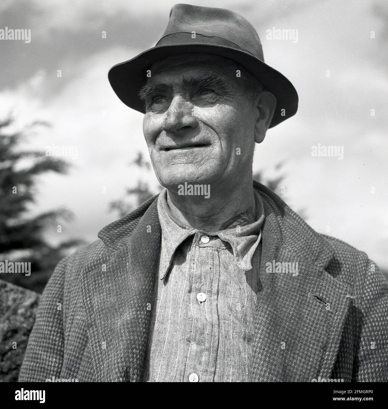 Années 1950, photo historique de J Allan Cash, profil d'un agriculteur, Irlande du Nord. La vie sur une ferme à cette époque était dure et les hommes, qui travailleraient souvent 24 heures sur 24, étaient eux-mêmes de nature dure. Banque D'Images