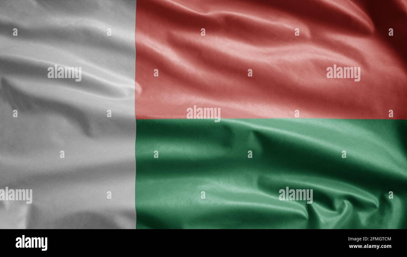 Drapeau malgache agitant dans le vent. Gros plan de la bannière de Madagascar soufflant, doux et lisse soie. Tissu texture ensign arrière-plan. Utilisez-le pour nati Banque D'Images