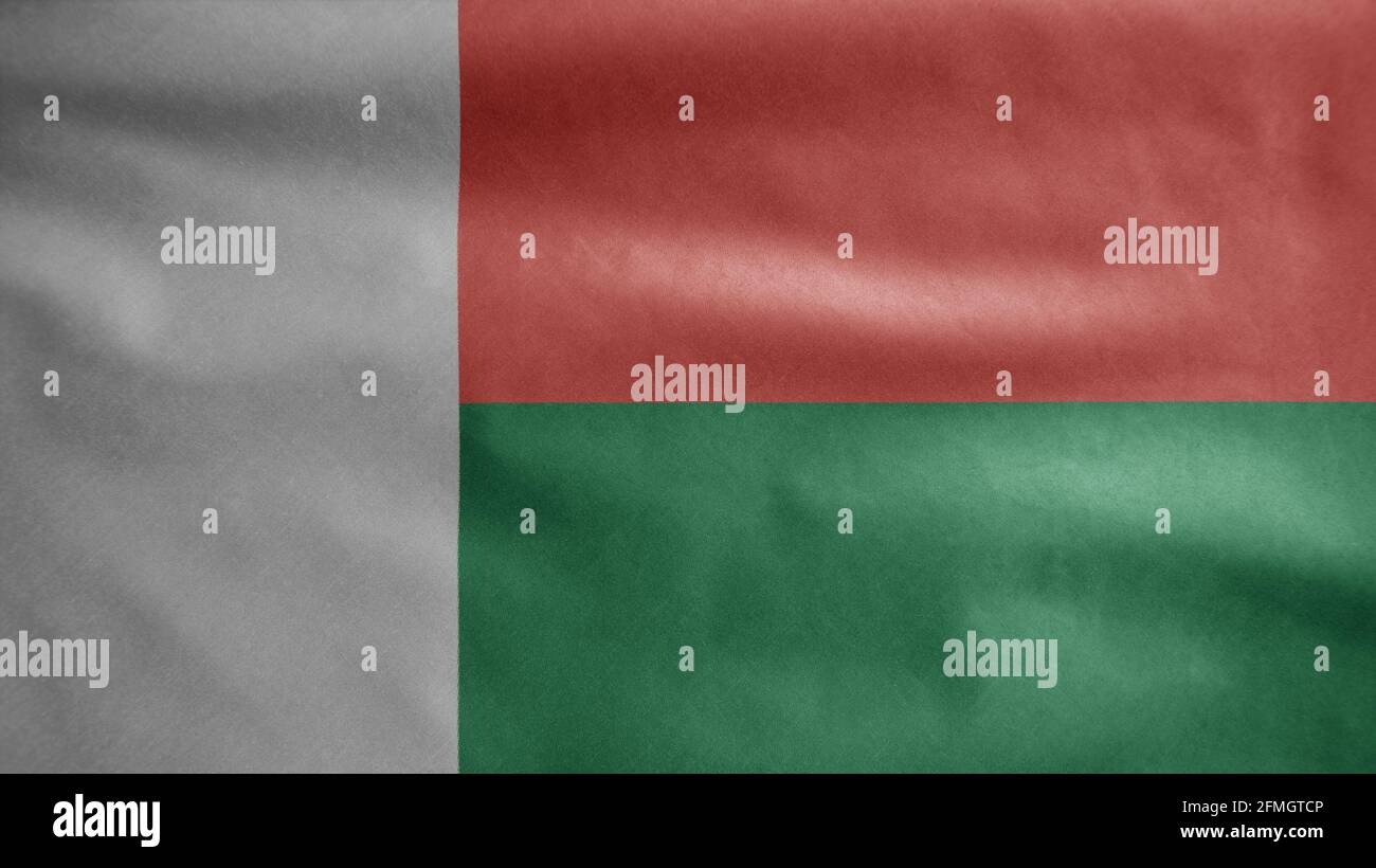 Drapeau malgache agitant dans le vent. Gros plan de la bannière de Madagascar soufflant, doux et lisse soie. Tissu texture ensign arrière-plan. Banque D'Images