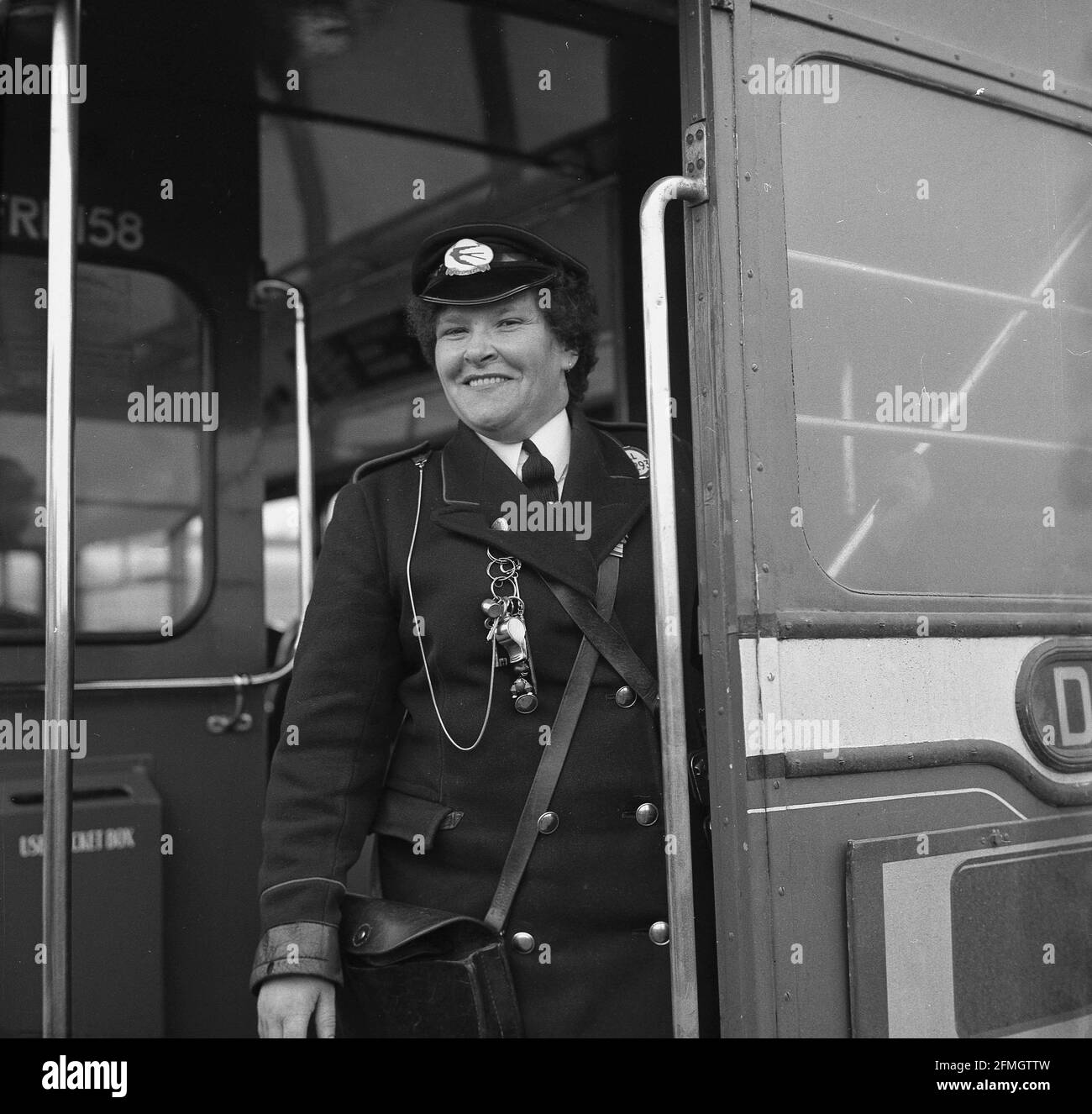 Années 1960, historique, un chef d'autobus féminin debout à l'entrée arrière, près de l'escalier, d'un autobus routemaster à impériale, Écosse, Royaume-Uni. Ces dames étaient connues sous le nom de « clippies » pendant la Seconde Guerre mondiale en raison de leurs machines à billets qui « clippaient » les billets. Les conducteurs, à la fois femelles et mâles, étaient une partie essentielle du fonctionnement d'un bus à impériale étant à l'extrémité opposée du conducteur qui était dans une cabine scellée. Banque D'Images