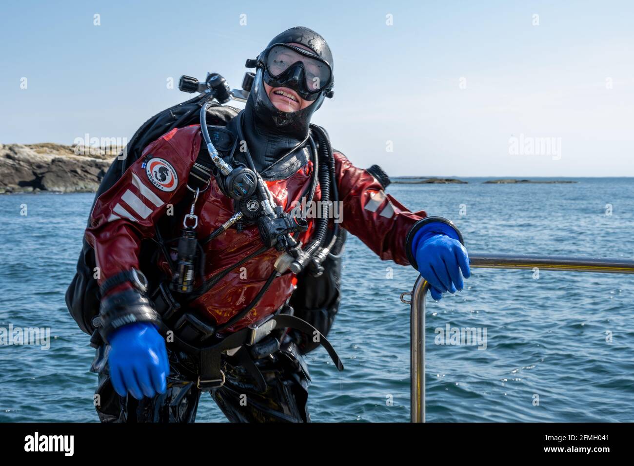 17 avril 2021 - Hamburgsund, Suède: Une femelle plongée en scaphandre autonome vient de rentrer au bateau de plongée et de poser pour une photo. Océan et ciel bleu en arrière-plan Banque D'Images