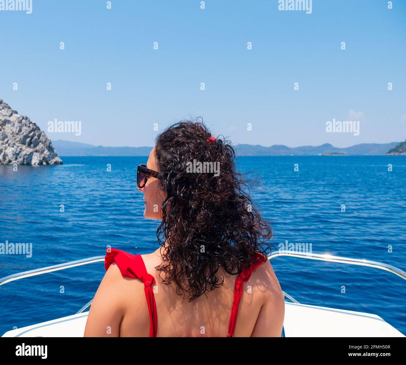Vue depuis l'arrière de la belle femme assise sur la terrasse du bateau. Concept de vacances en mer d'été. Copier l'espace Banque D'Images