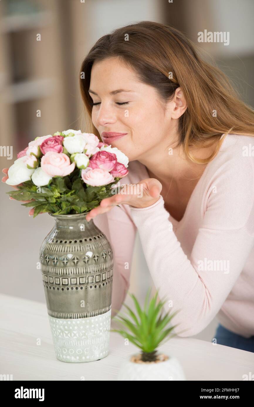 Young woman smelling flowers Banque D'Images