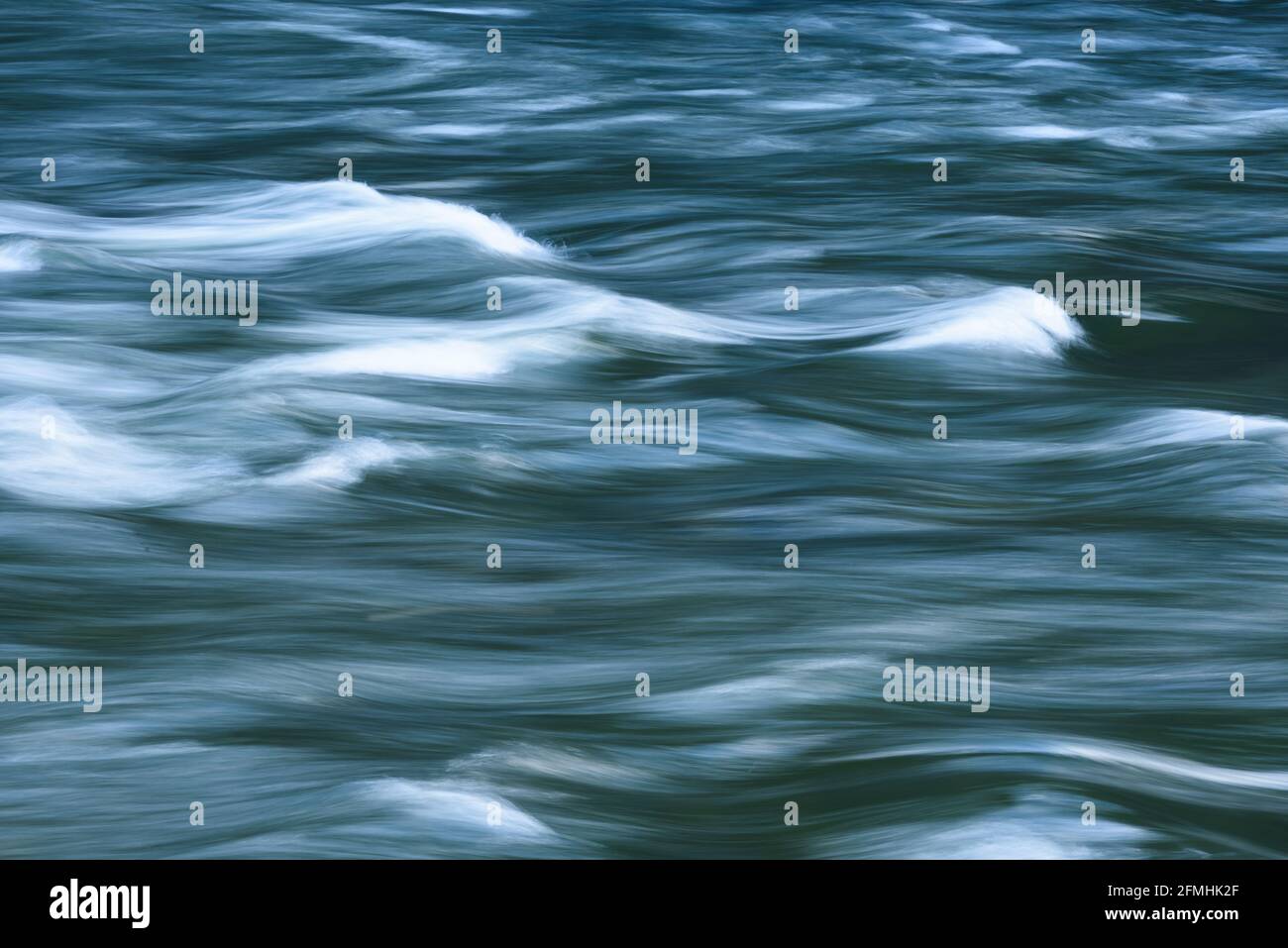 Résumé d'une rivière fluide capturé au ralenti avec bouchons blancs dans un mouvement de roulement de courbes de balayage Banque D'Images