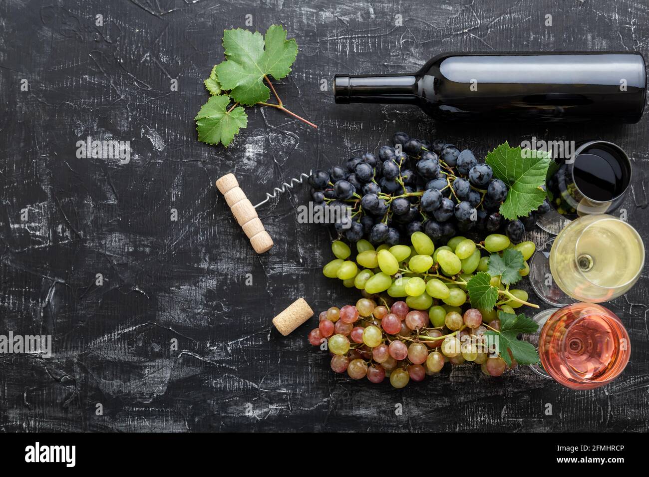 Assortiment différents types de vin et variétés de qualité. Dégustation de vin rouge rose blanc en verres près du raisin blanc rose et noir, bouteille de vin rouge Banque D'Images