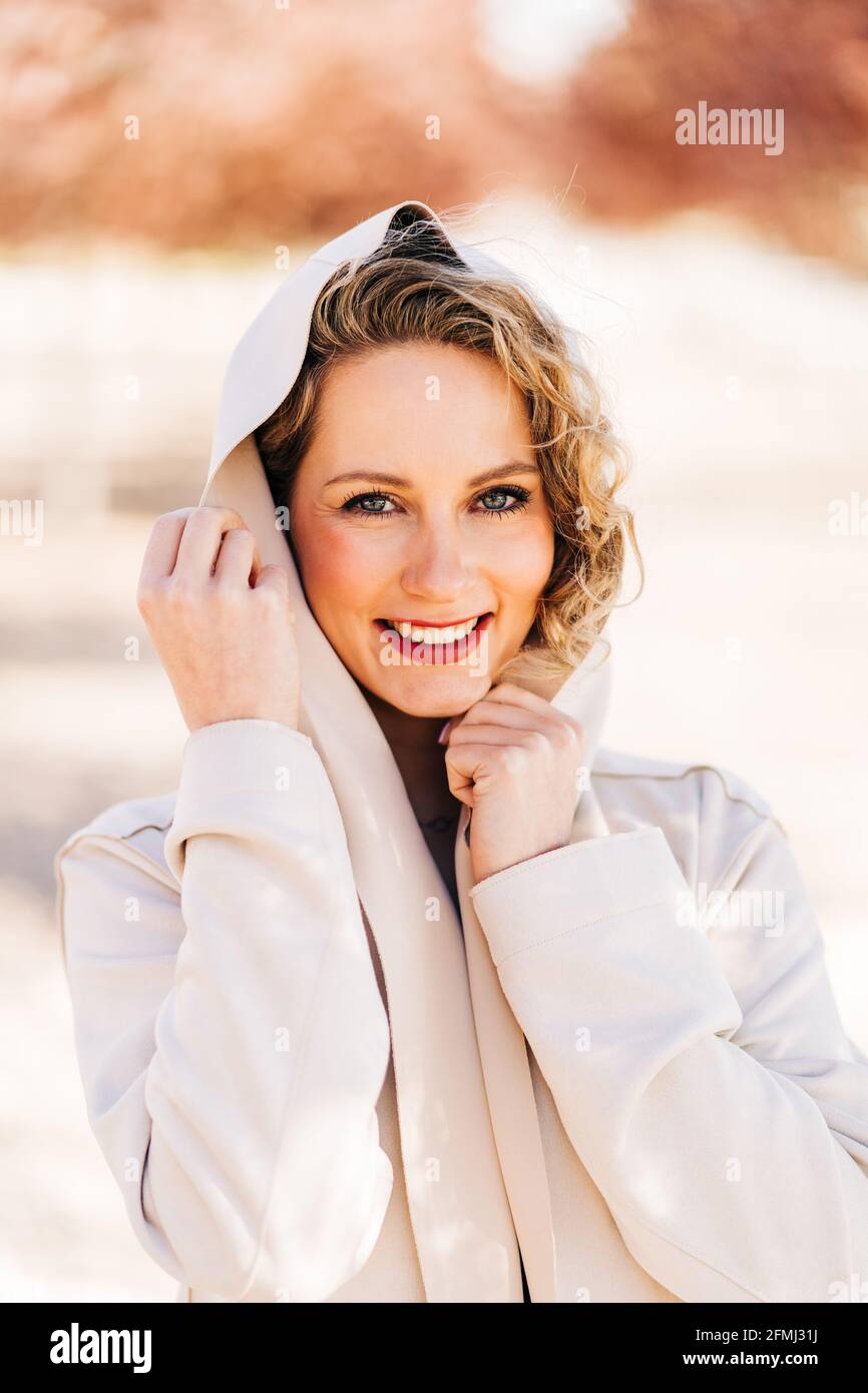 Bonne femme dans une robe élégante et manteau marchant le long de l