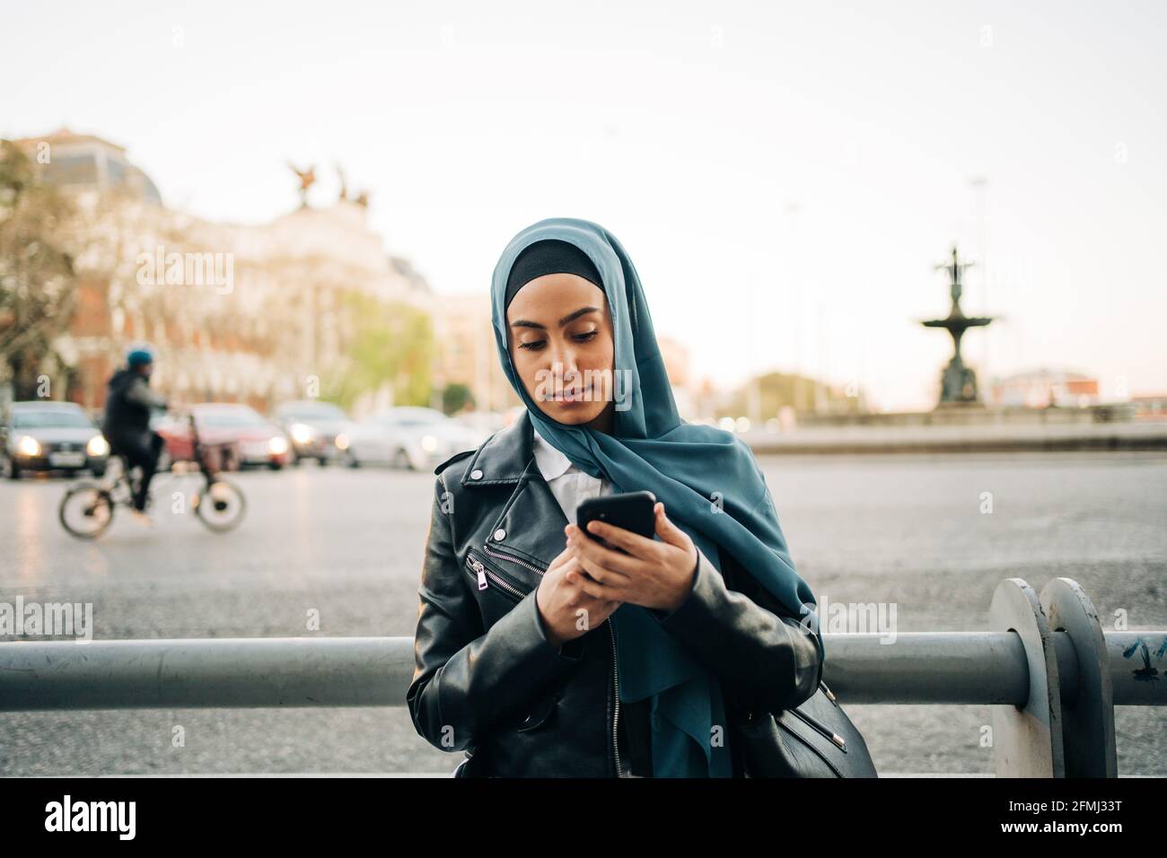 Femme musulmane en foulard sur la rue et la navigation téléphone portable Banque D'Images