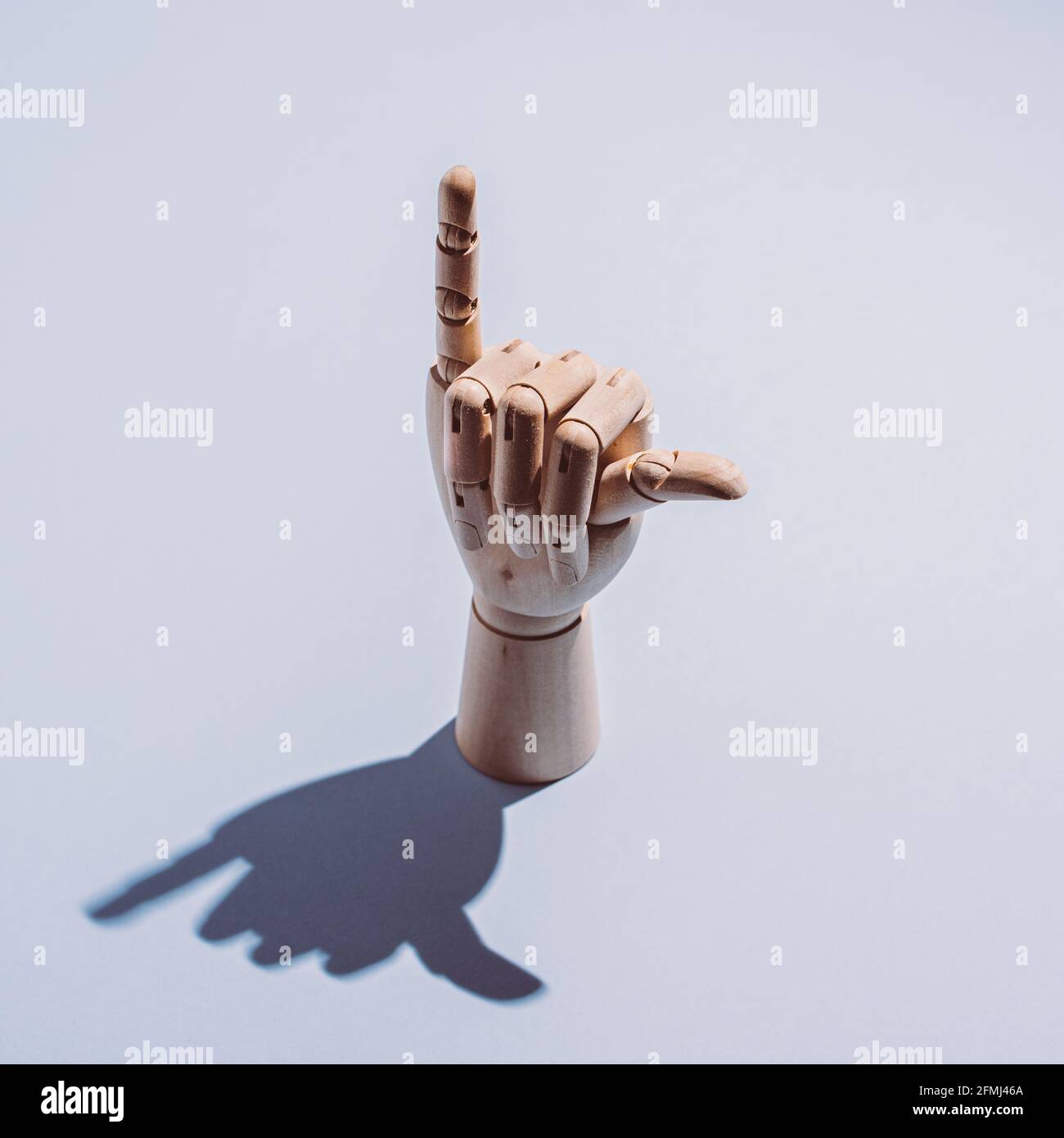 De dessus de la main de mannequin en bois flexible décorative montrant le shaka affiche placée sur fond blanc Banque D'Images