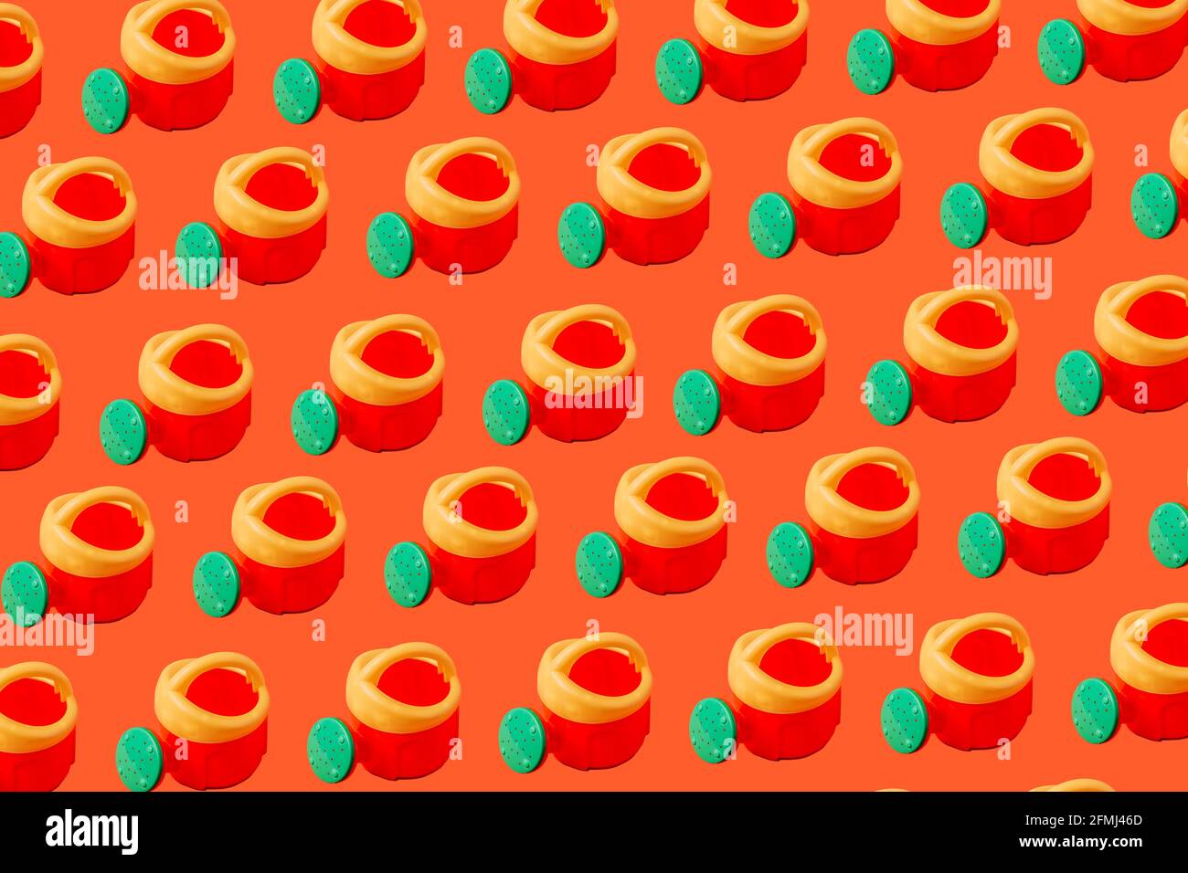 Illustration colorée représentant des arrosoirs en plastique avec poignée colorée sur fond orange Banque D'Images