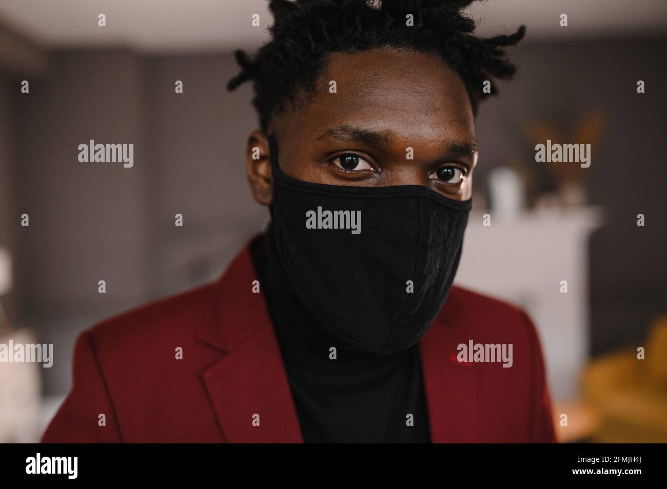 portrait d'un afro-américain dans un costume porte un masque médical noir Banque D'Images