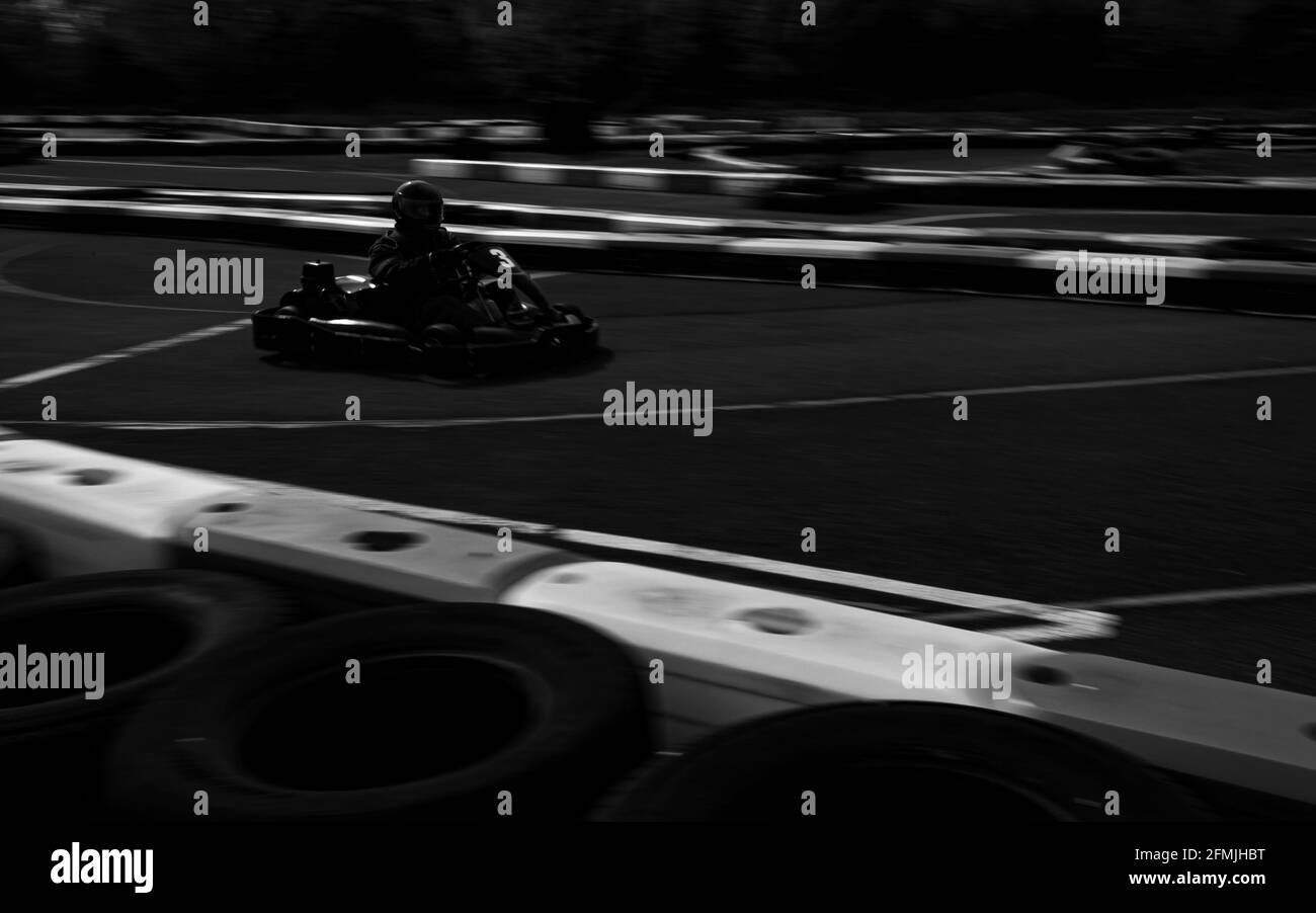 Un cliché panoramique d'un kart de course pendant qu'il circuit une piste. Banque D'Images