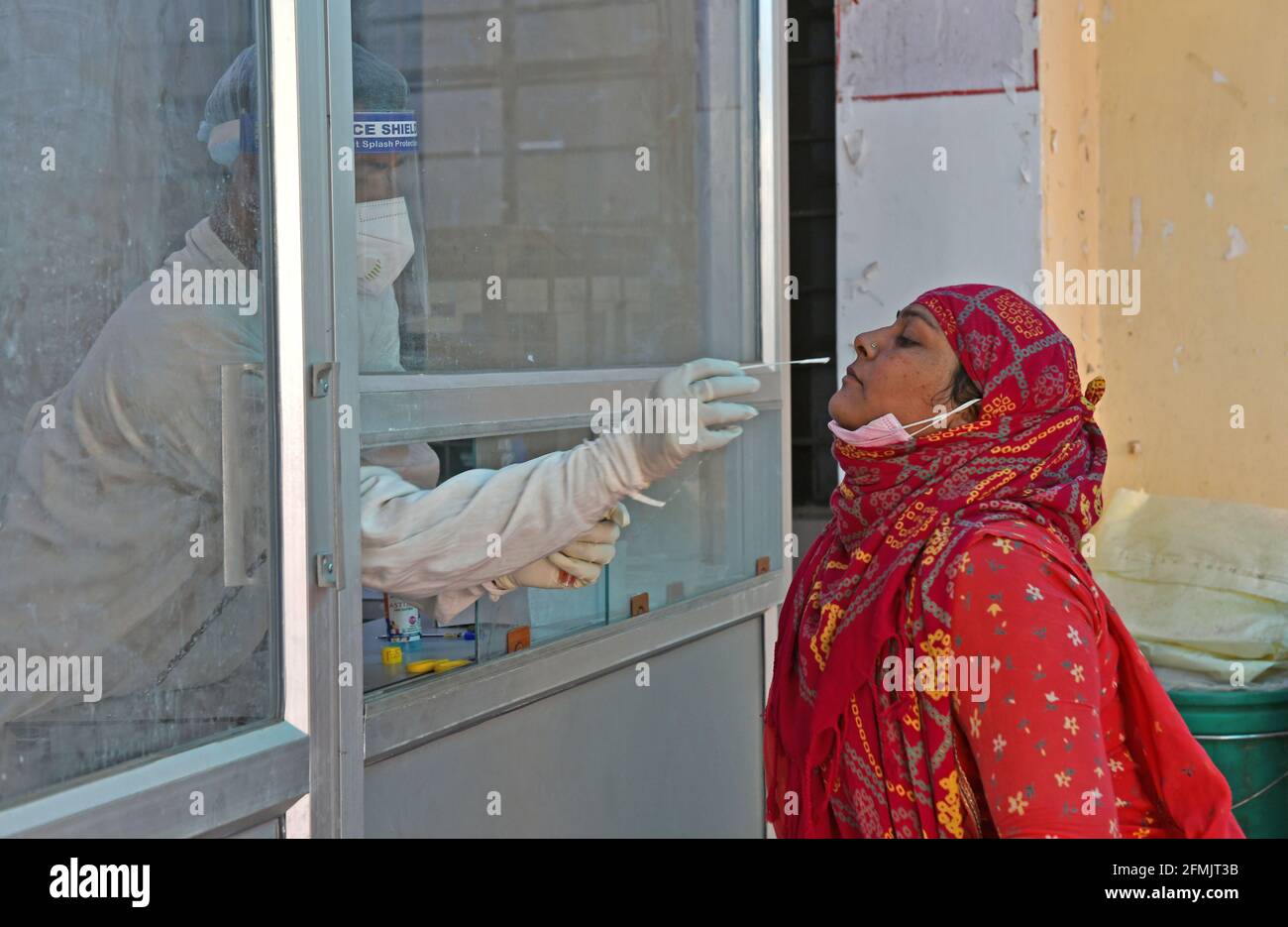 Beawar, Rajasthan, Inde, 10 mai 2021 : un agent de santé recueille un échantillon d'écouvillonnage auprès d'une femme du village dans un laboratoire de test COVID-19 pendant la deuxième vague d'épidémie de coronavirus, à Beawar. Lundi, le ministère de la Santé a signalé 366,161 nouvelles infections et 3,754 décès. Le nombre d’infections en Inde s’élève aujourd’hui à 22.66 millions, dont 246,116 000 morts. 80 médecins de l'hôpital Saroj de Delhi ont été testés positifs pour le coronavirus. Crédit : Sumit Saraswat/Alay Live News Banque D'Images