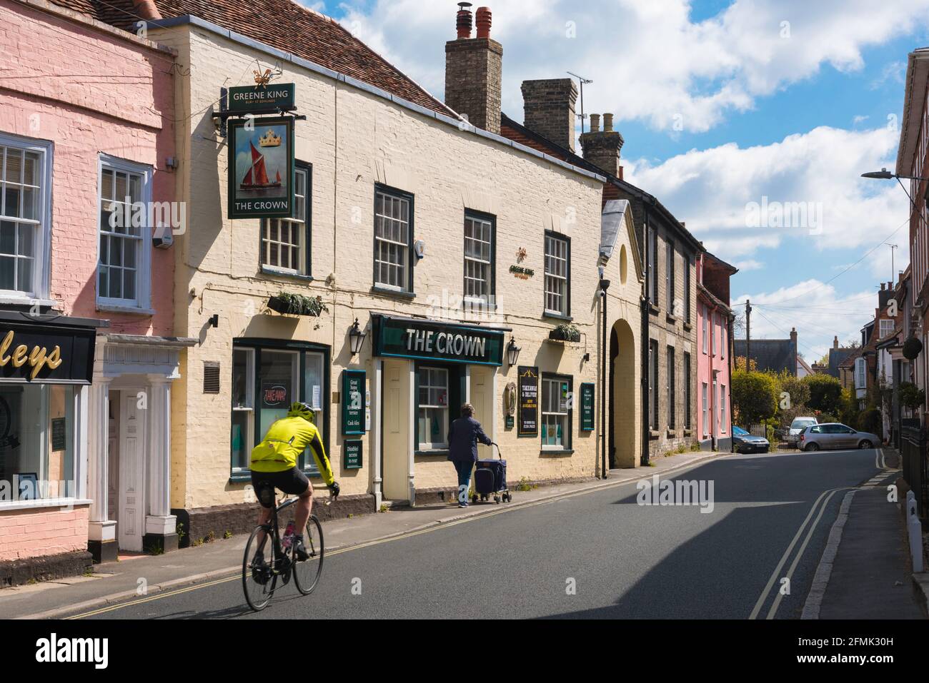 Manningtree UK, vue d'un cycliste passant devant le pub Crown à Manningtree High Street, Essex, Angleterre, Royaume-Uni Banque D'Images
